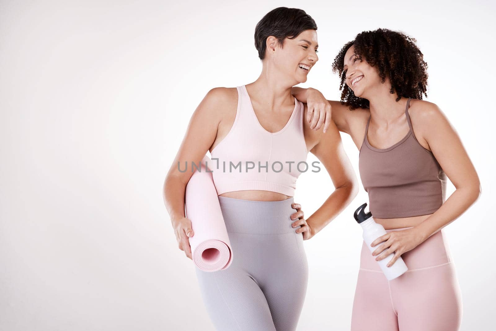 Mixing fun with fitness. two attractive young female athletes posing in studio against a grey background. by YuriArcurs