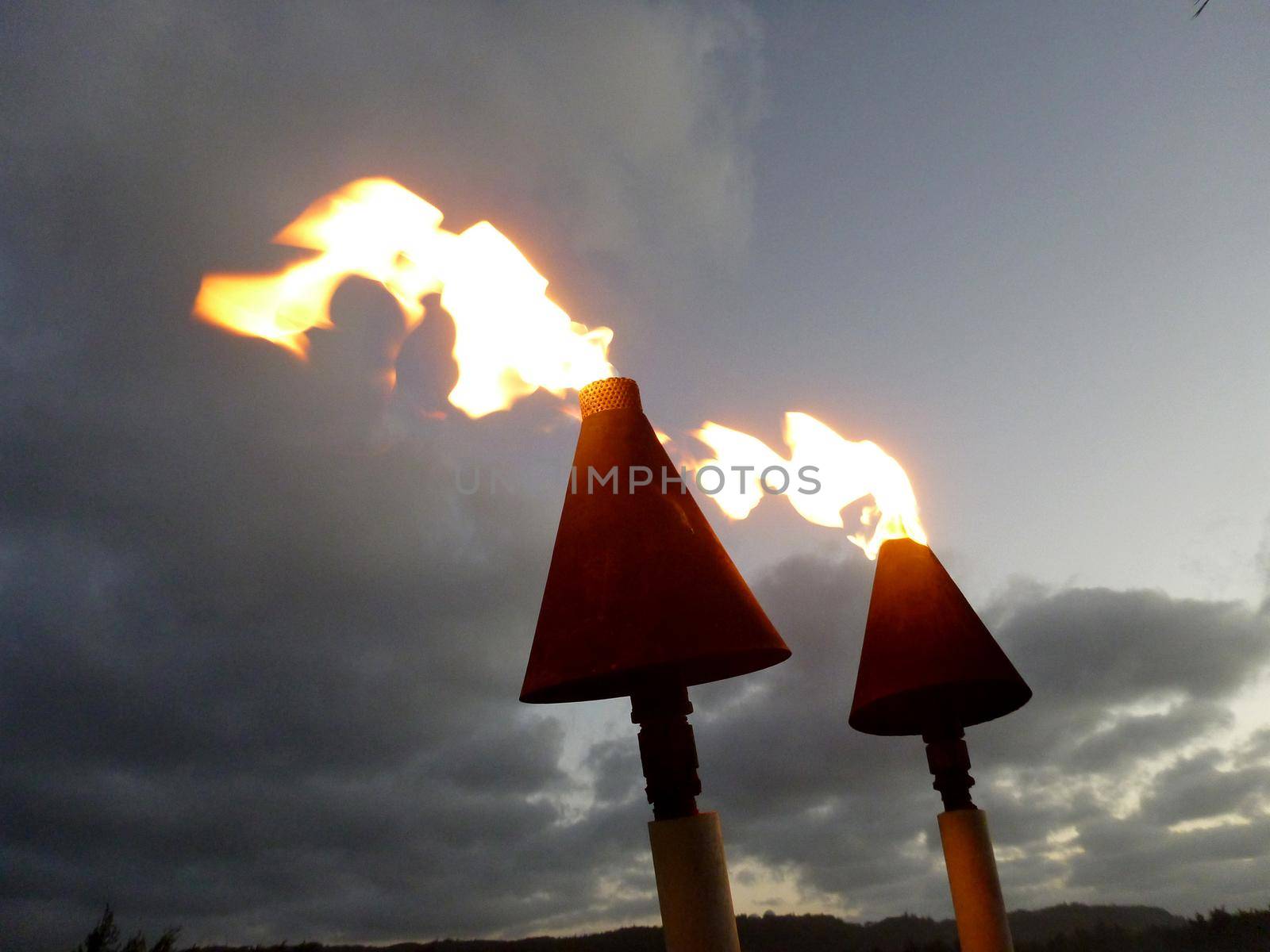 Flames burn from Tiki torches at dusk on the North Shore of Oahu.