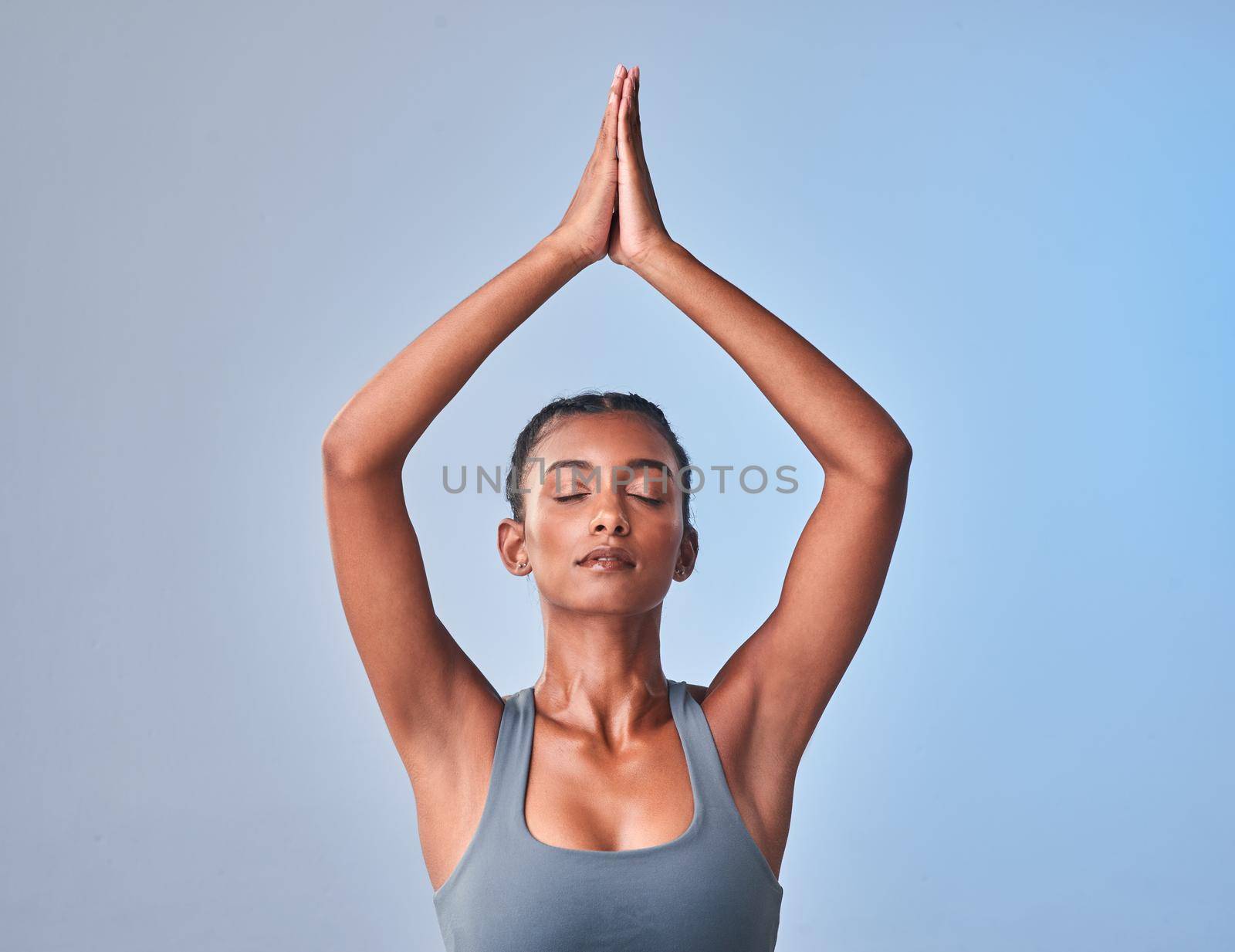Meditation is medicine for the mind. Studio shot of a fit young woman meditating against a grey background. by YuriArcurs
