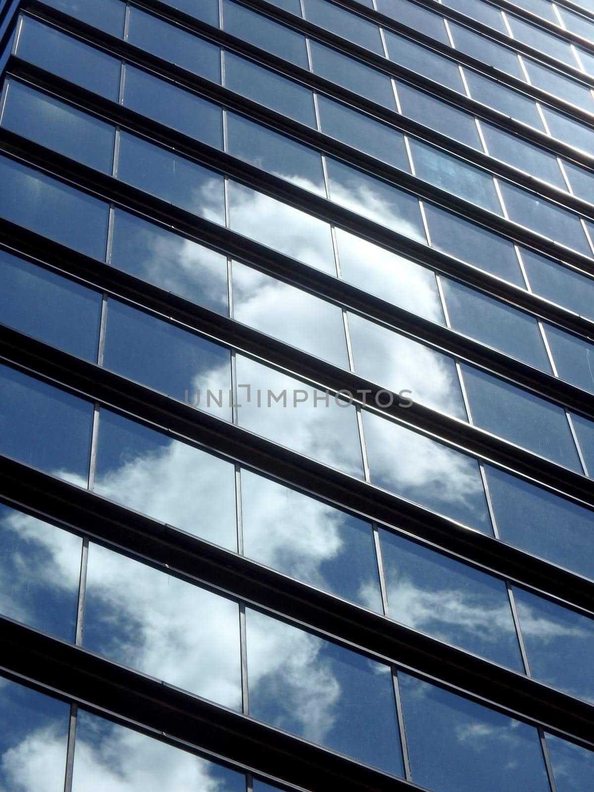 Blue Glass Windows reflect clouds and sunlight with lines framing windows.