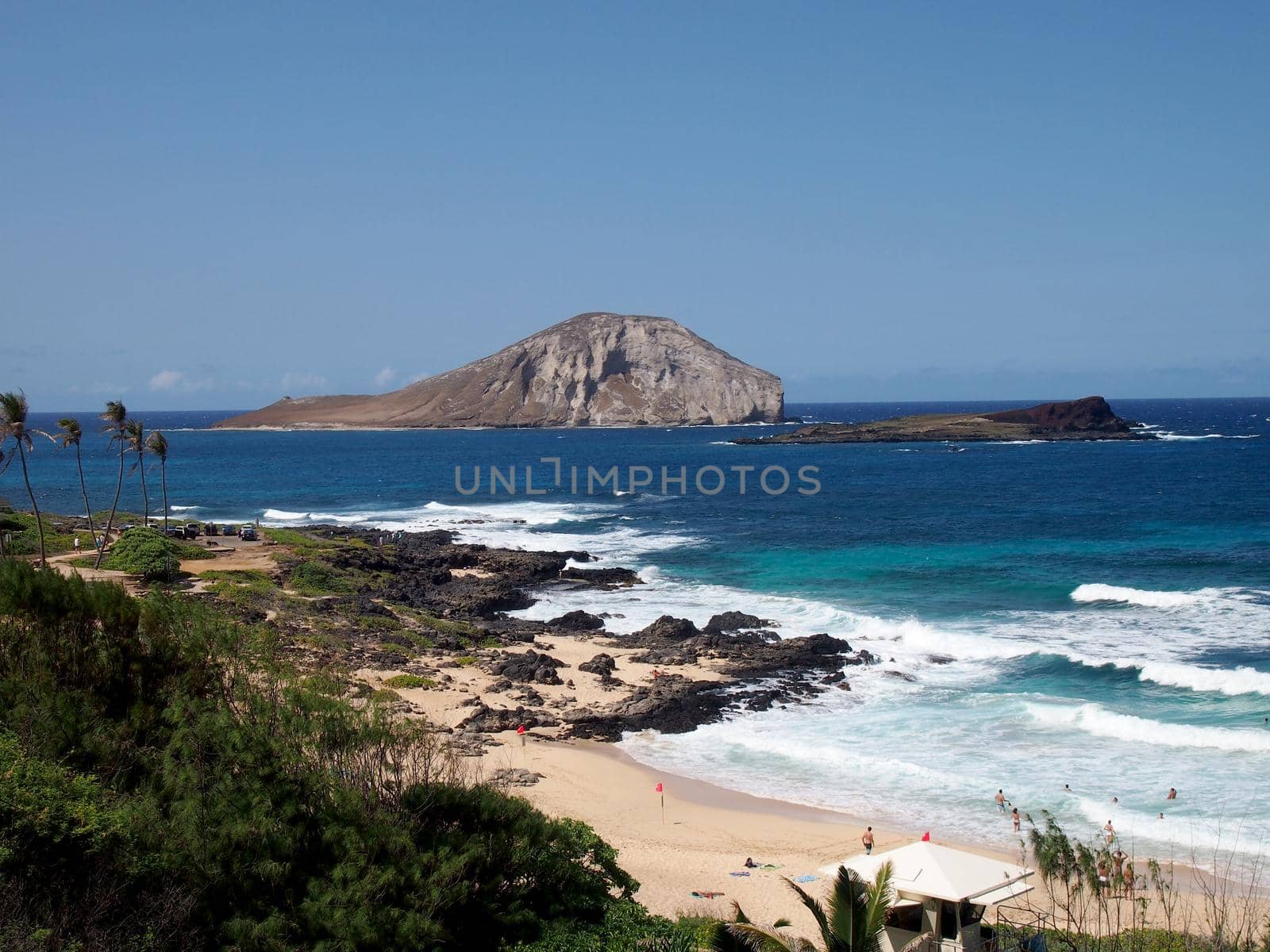 Waves crash on Makapuu Beach with Rabbit and Rock islands in the distance looking towards Waimanalo Bay by EricGBVD