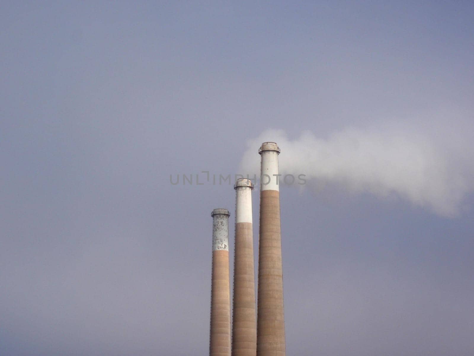 Three Smokestacks of the same size put pollution into the air in California.