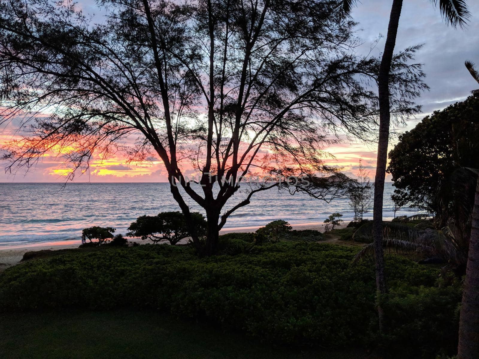 Red light fills the sky during Dawn on Waimanalo Beach.