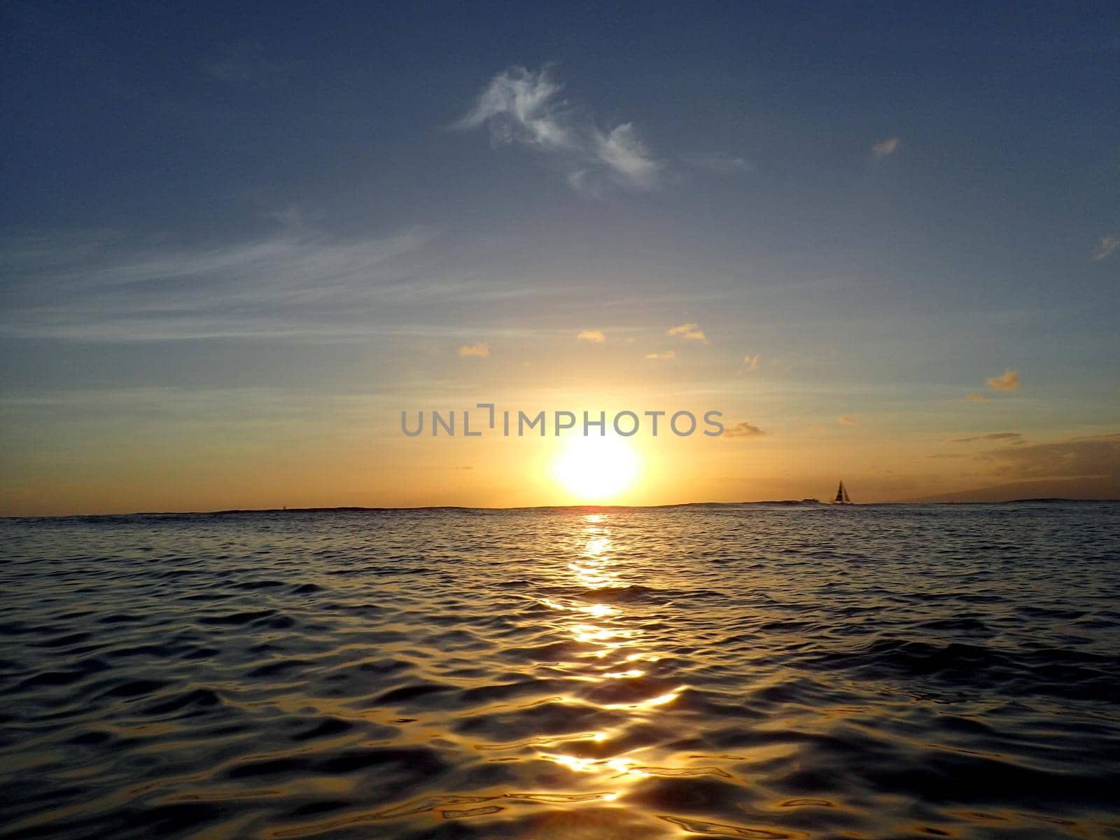 Sunset lowering to the ocean off Kaimana Beach with boats on the water  by EricGBVD