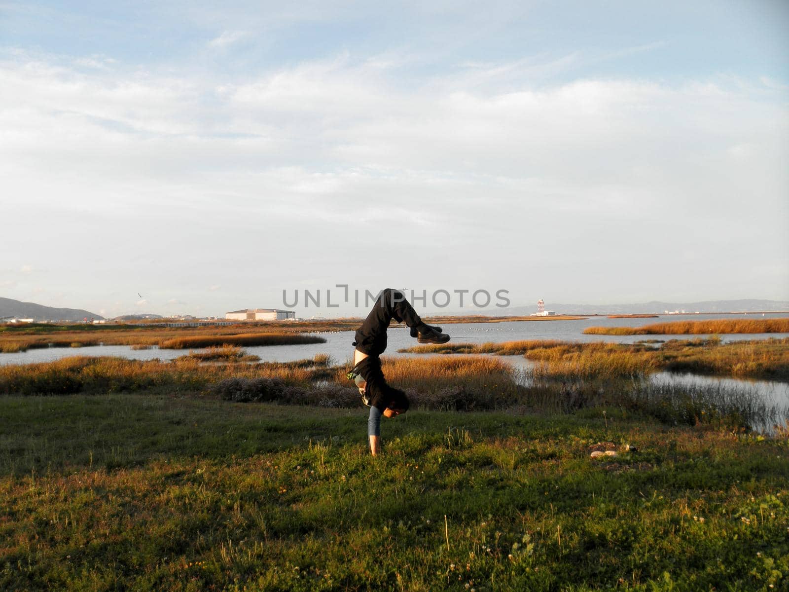 Man does a Handstand in the Marshes outside of SFO Airport by EricGBVD