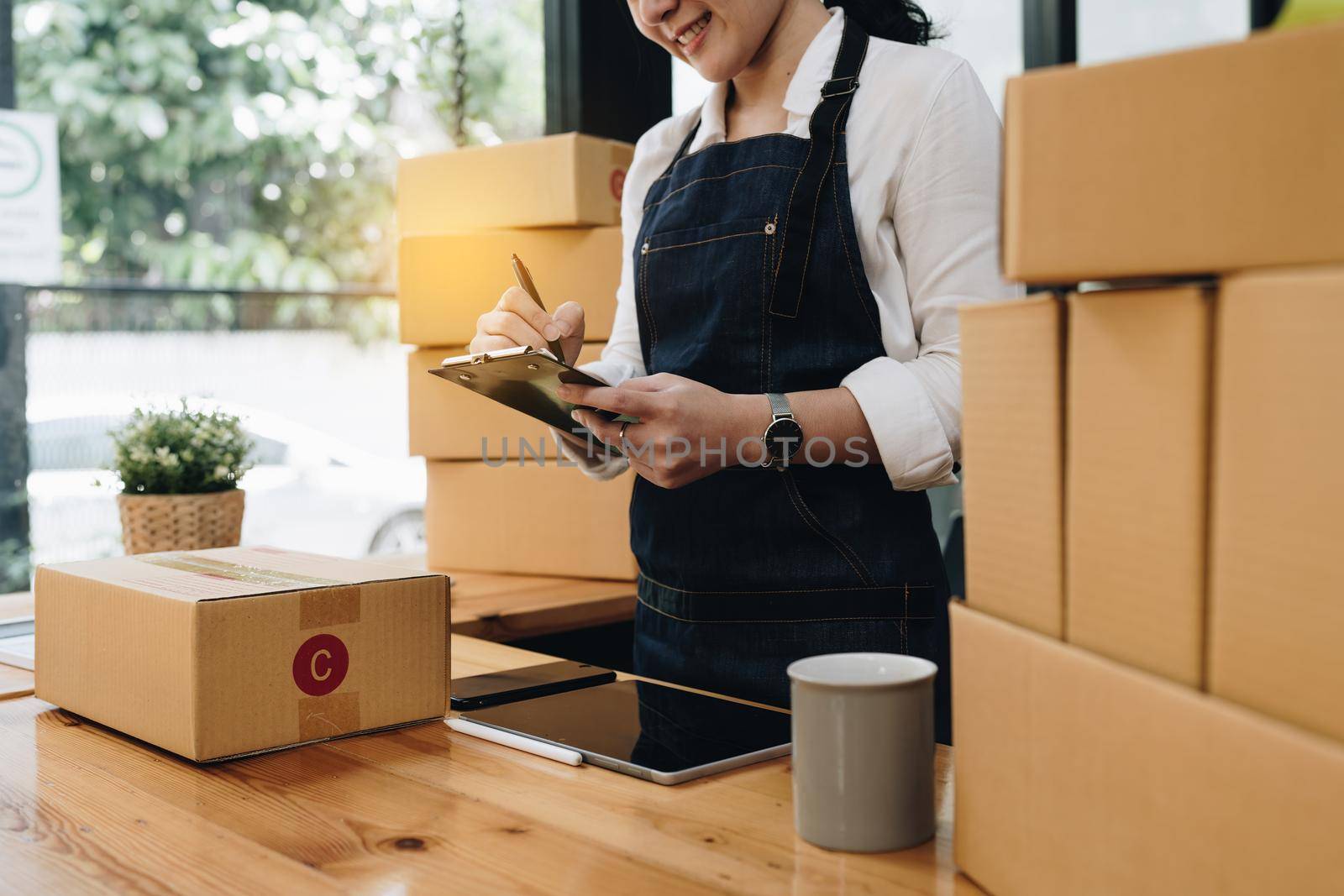 Attractive Asian SME business woman checking order at warehouse