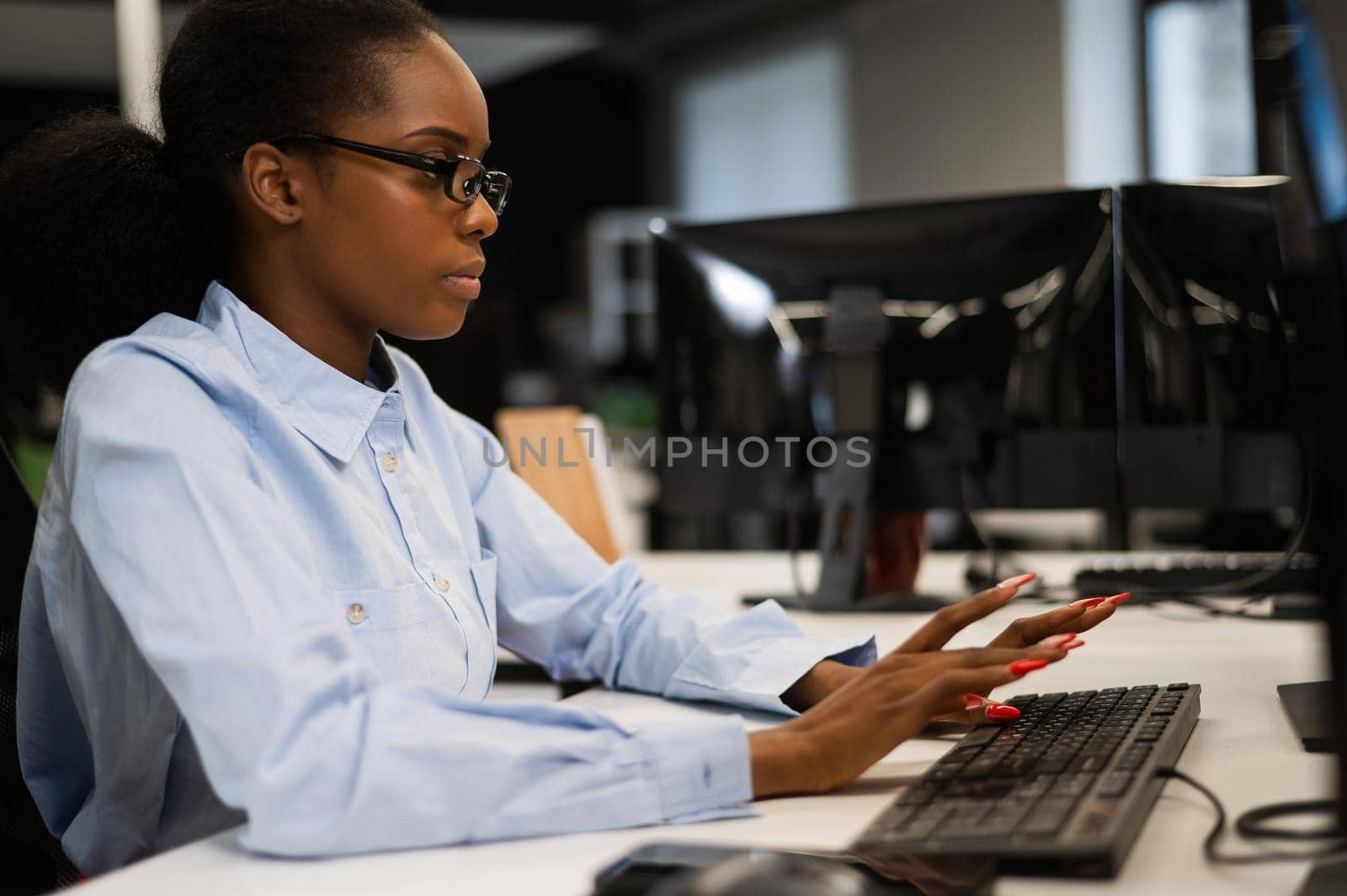 African young woman talking at her desk in the office