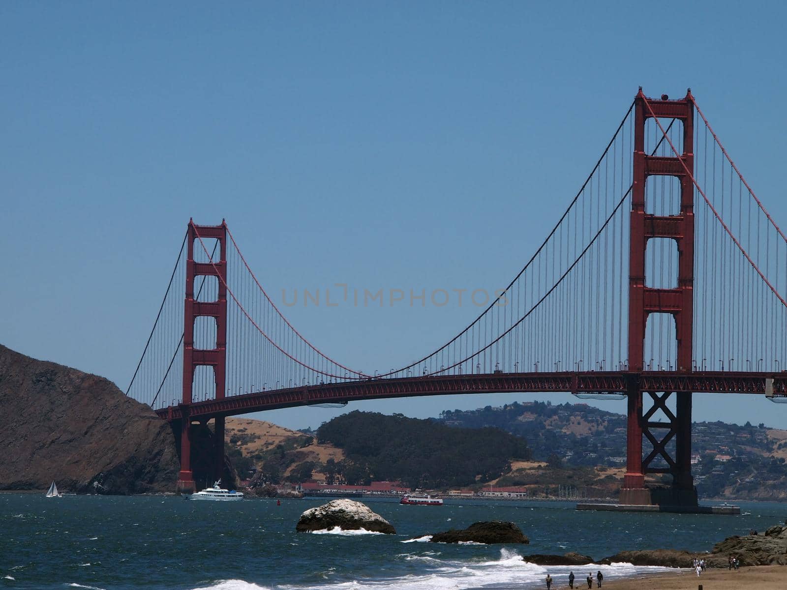 Baker Beach, Boats in the water, and Golden Gate Bridge in the distances in San Francisco, California.