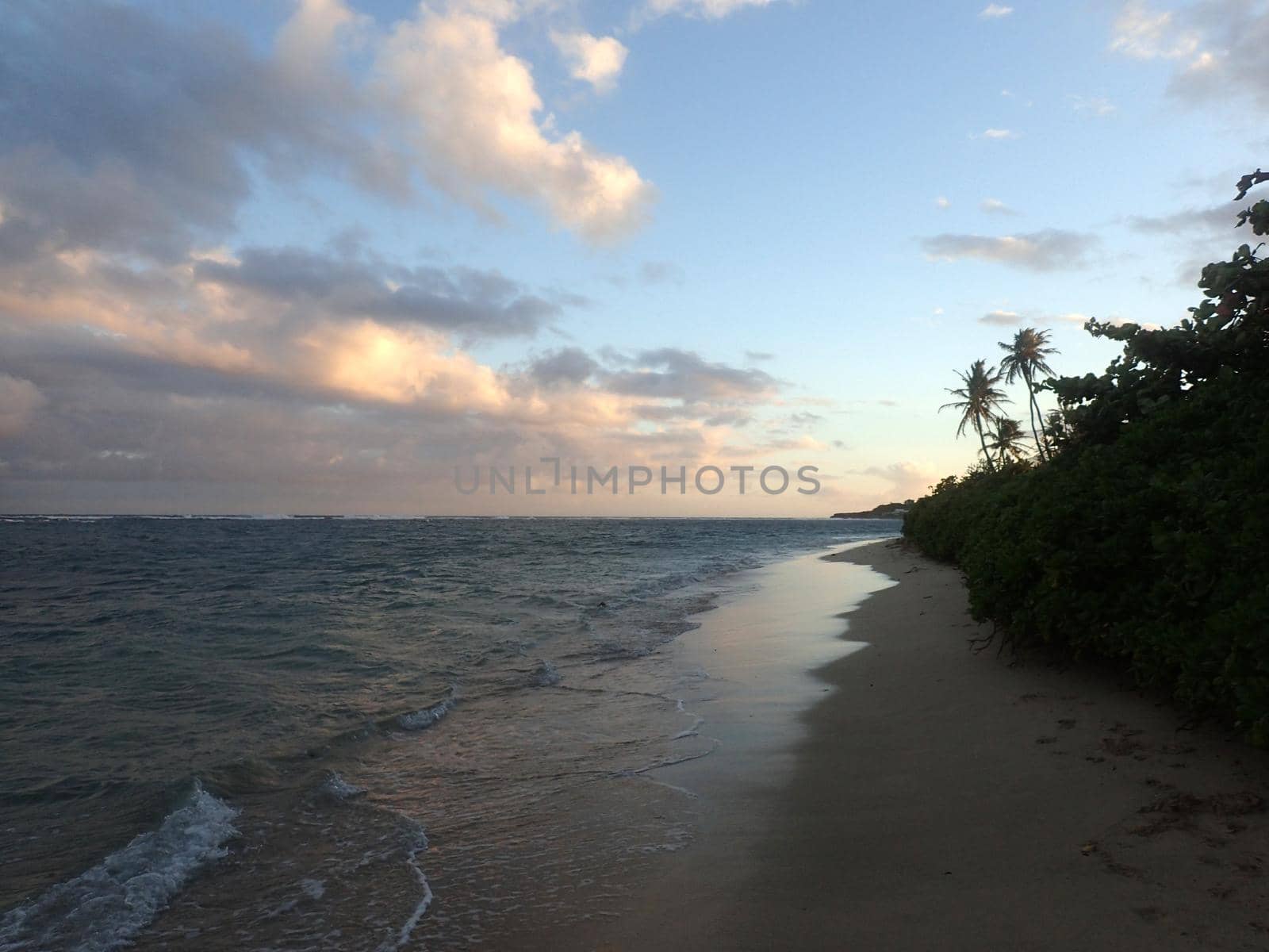 Sandy shoreline of Kahala Beach and the southern coastline of Oahu, Hawaii.