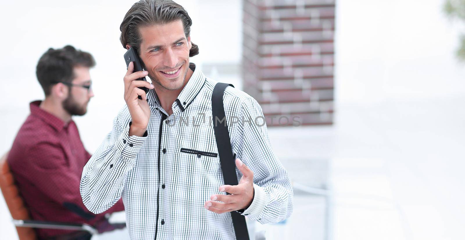 man talking on smartphone in office by asdf