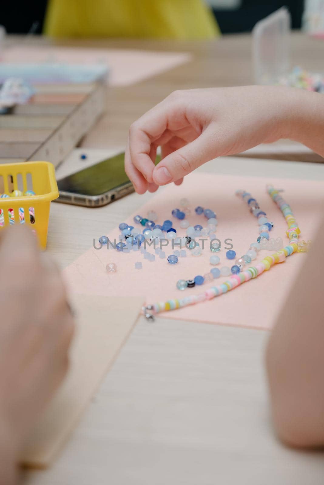 Jewelry making and beading process.The process of making jewelry.A woman makes jewelry in a workshop.Fashion, creativity and handmade concept