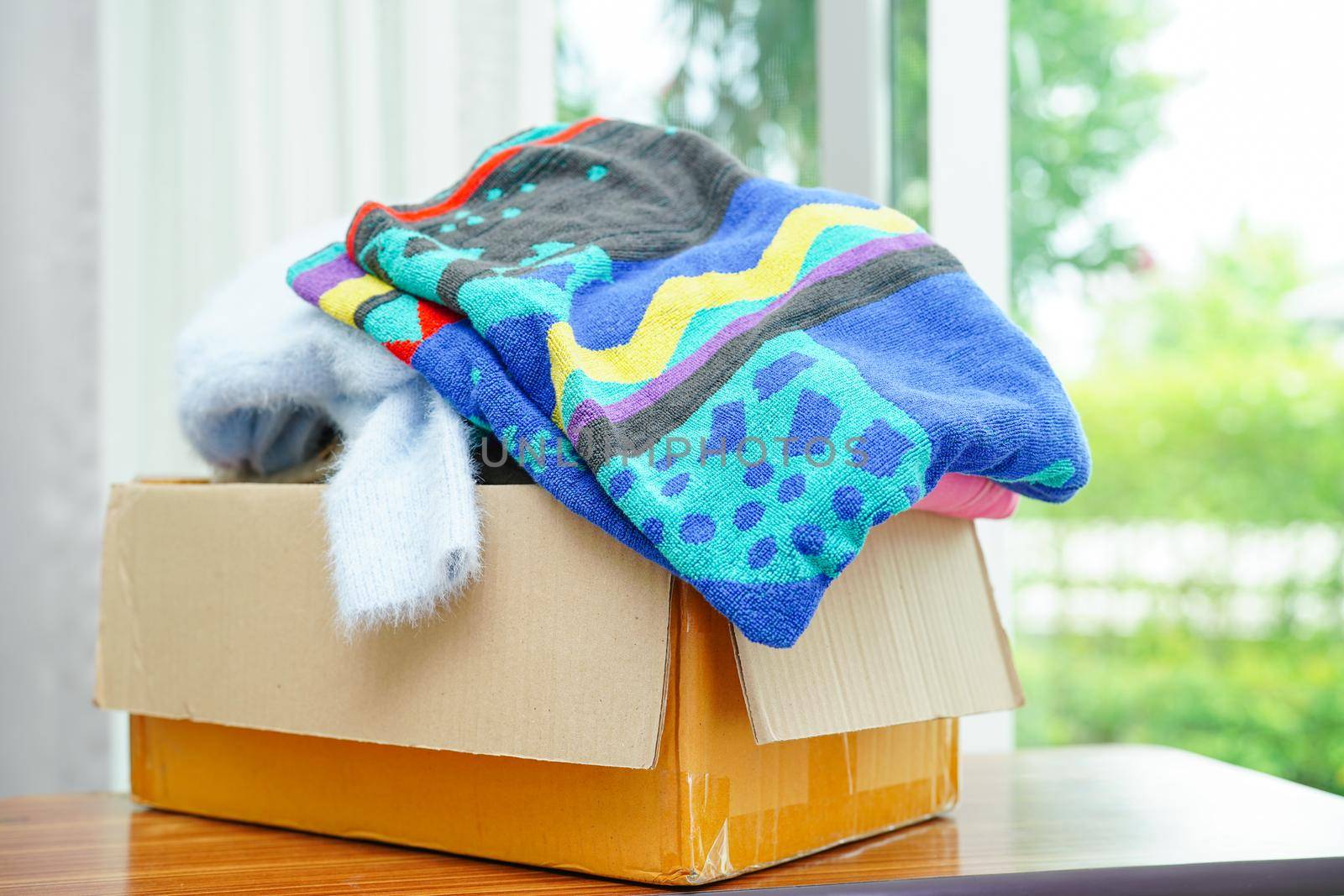 Clothes donations in cardboard box for volunteer.
