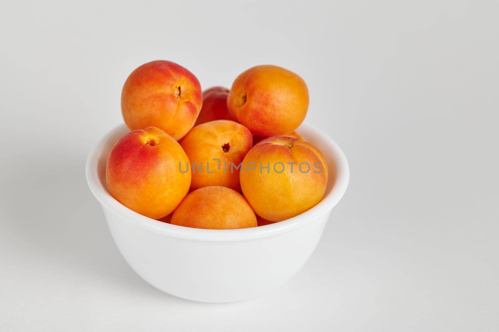Bowl of Ladakhi apricots on a white background