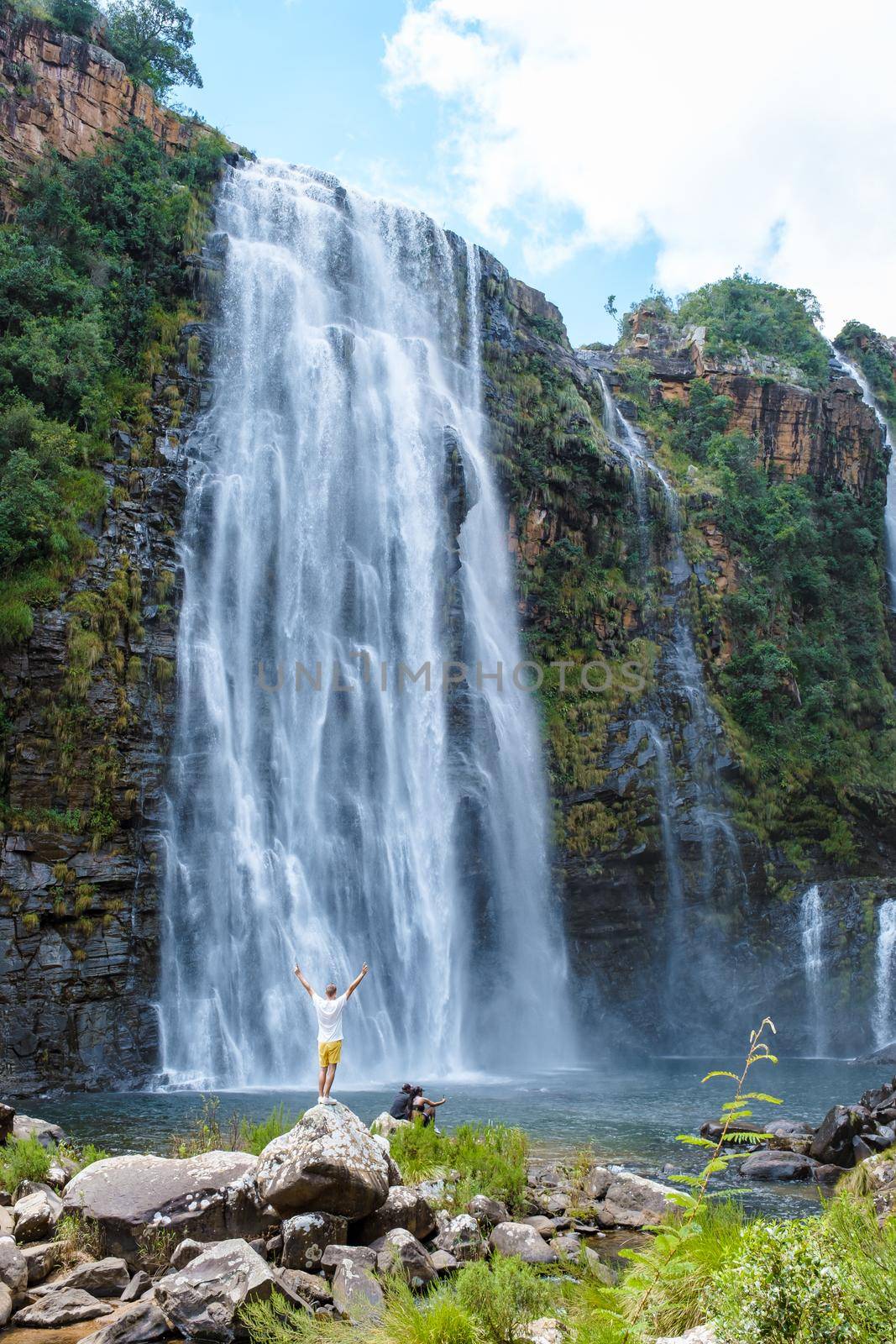 Panorama Route South Africa, Lisbon Falls South Africa, Lisbon Falls is the highest waterfall in Mpumalanga, South Africa. Caucasian men standing by a huge waterfall