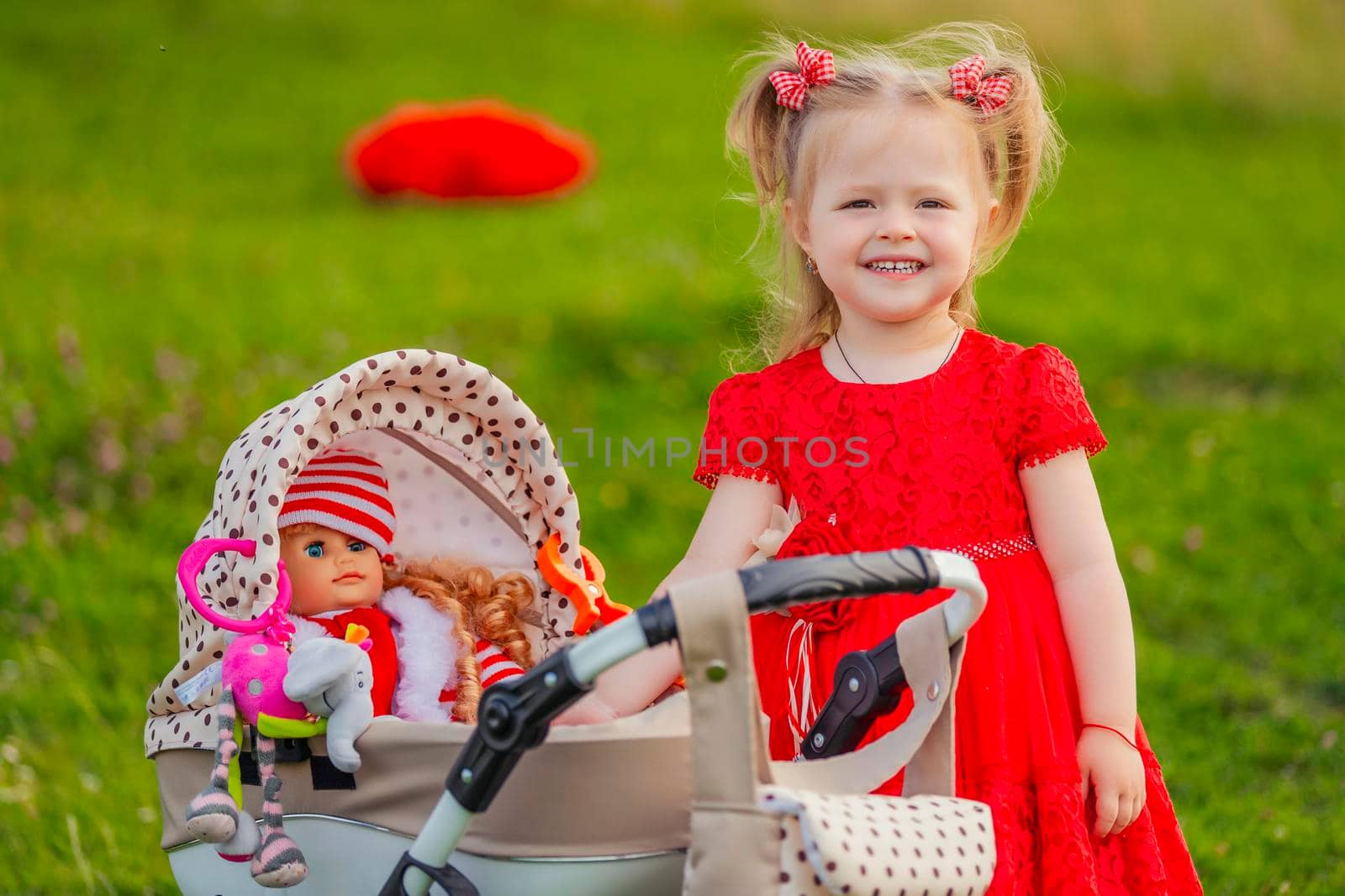 girl playing with a doll in a stroller in nature