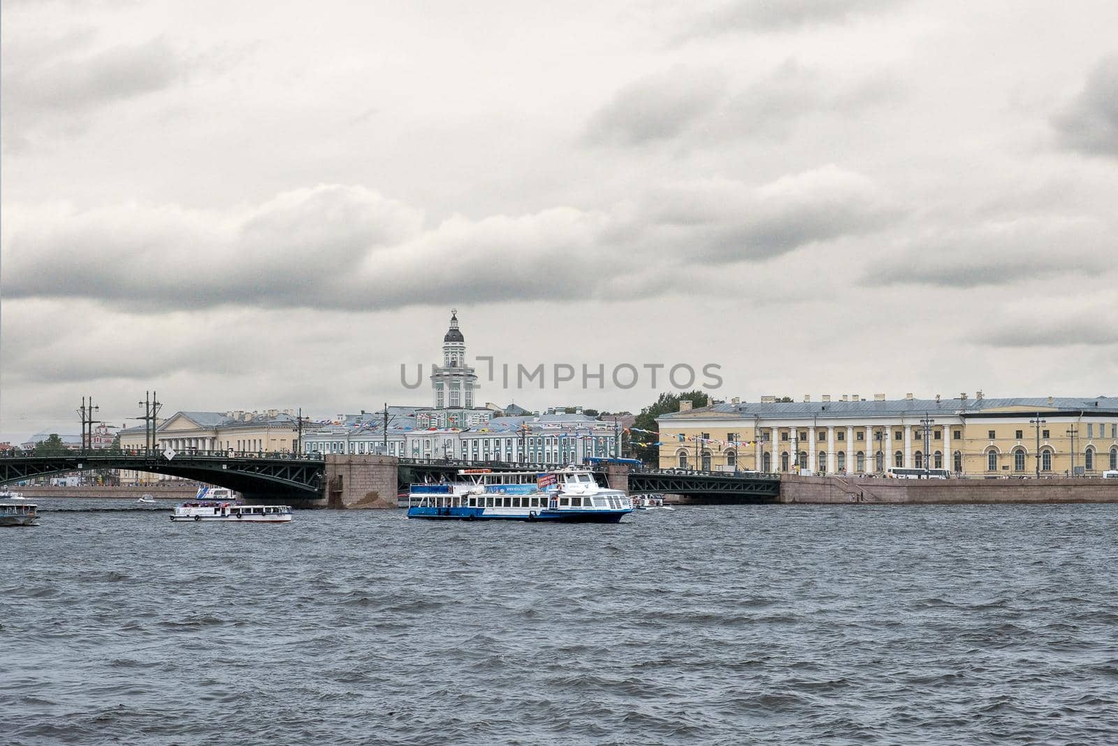 Saint-Petersburg, Russia. - July 27, 2002 View of the city across the waters of the Neva River with recreational water transport on a cloudy rainy summer evening. Selective focus.