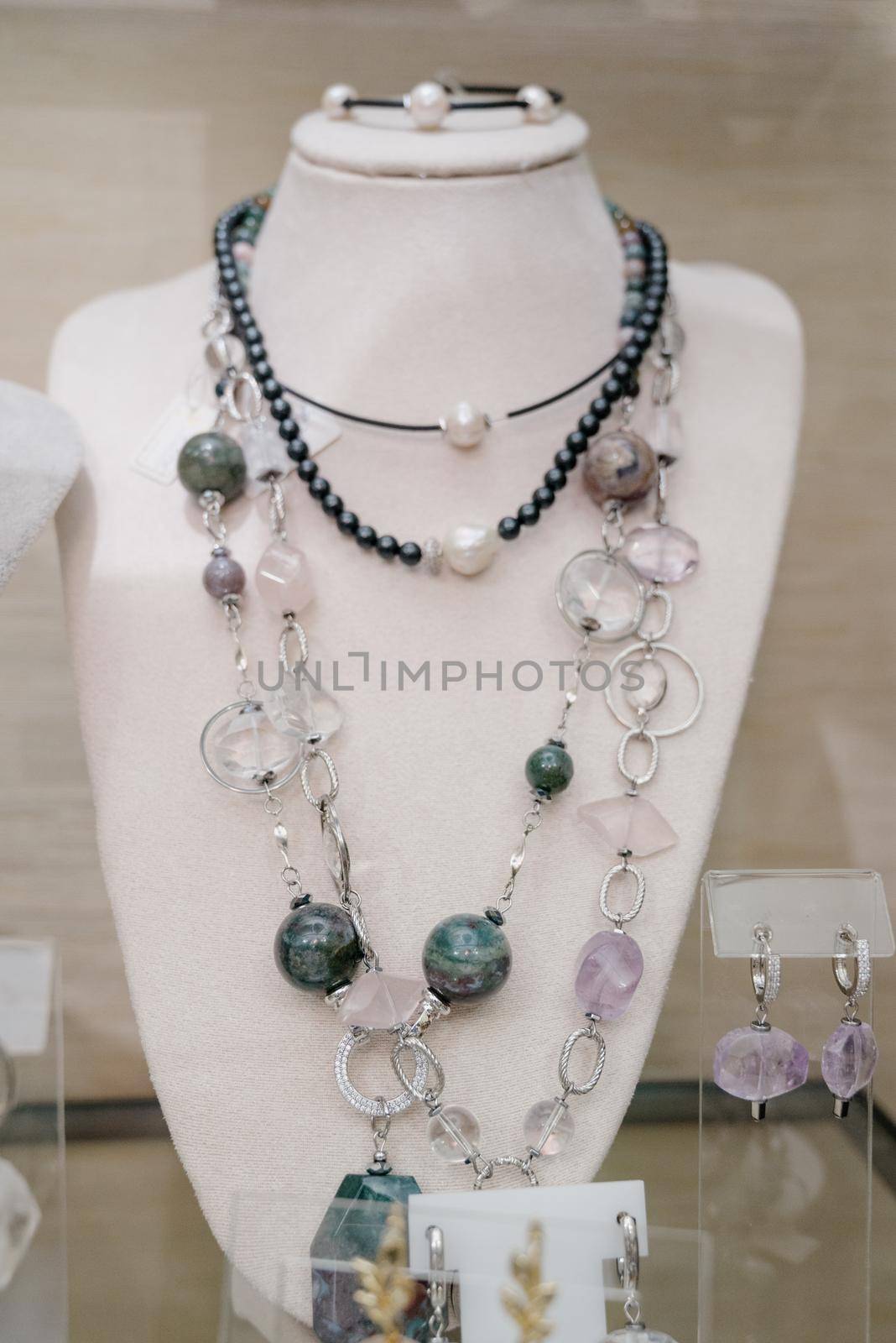 Shop window with necklaces and jewelry. Custome jewelry on display by Kovenkin