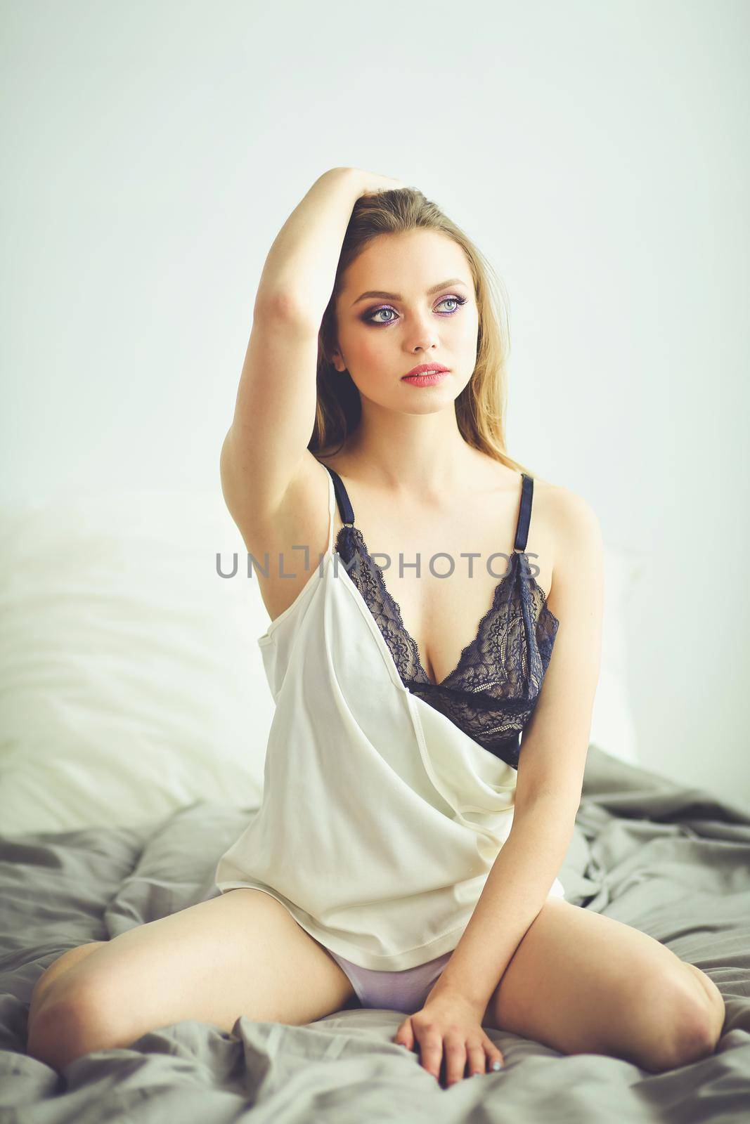 Portrait of beautiful young woman in nightwear on bed.