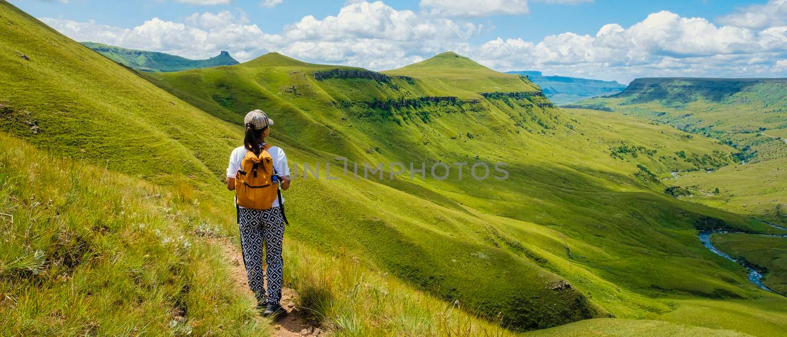 Young woman hiking in the mountains, .Drakensberg Giant Castle South Africa,Drakensberg mountain ,Central Drakensberg Kwazulu Natal, green mountains in South Africa, young Asian woman hiking