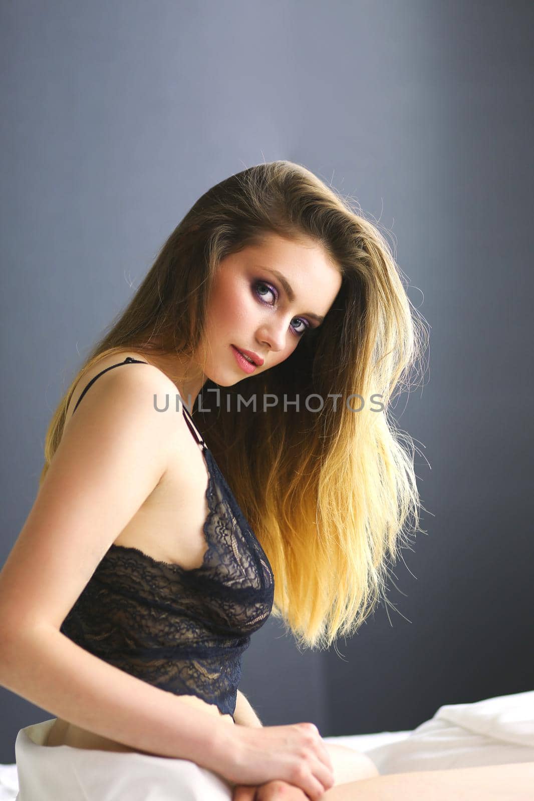 Portrait of beautiful young woman in nightwear on bed.
