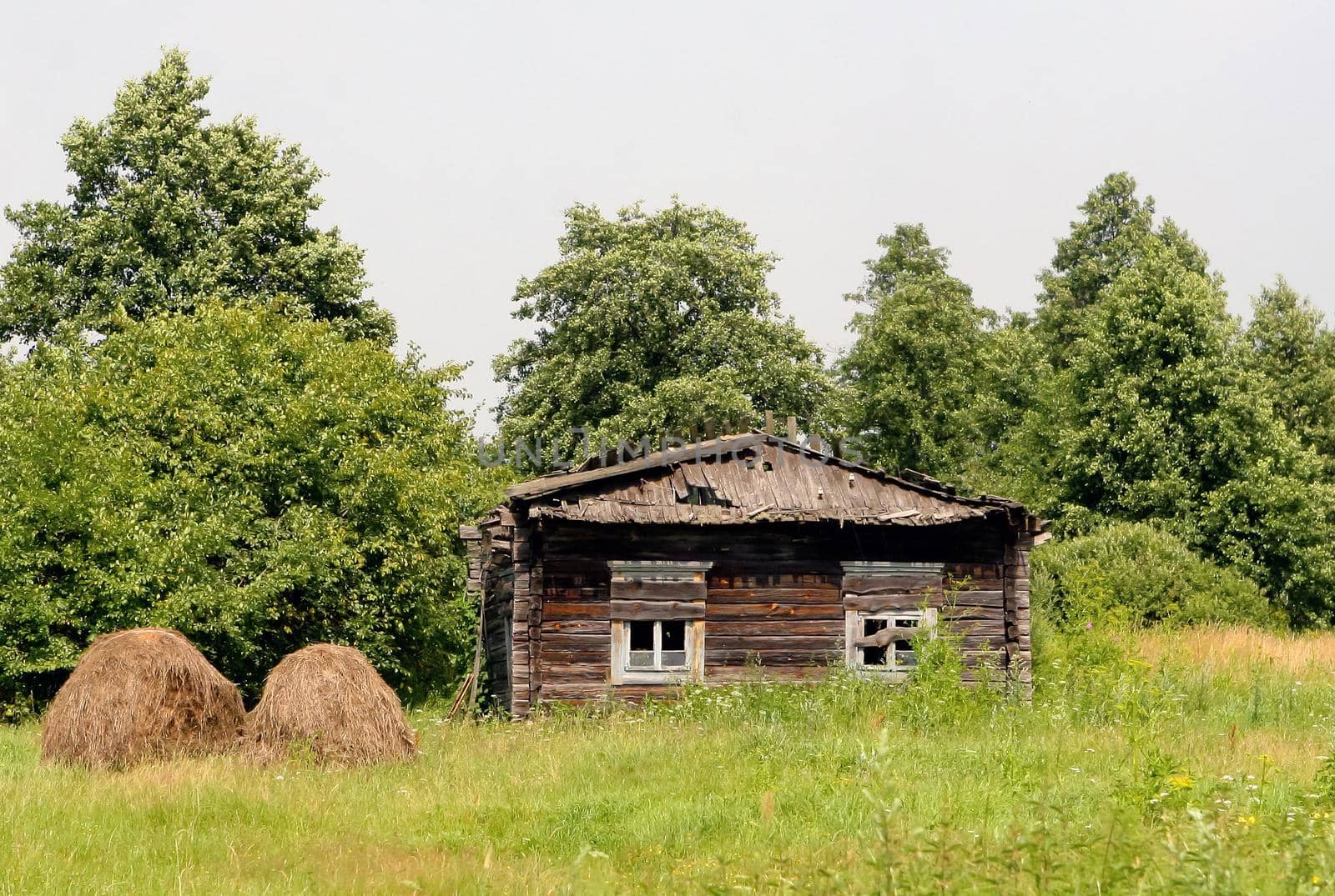 Abandoned house in disrepair in a field in the countryside.