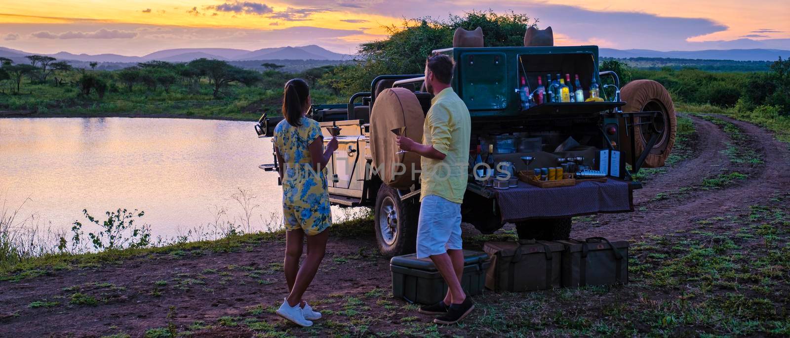 couple men and Asian woman on safari in South Africa, South Africa Kwazulu Natal, luxury safari car during a game drive, couple men and woman on safari in South Africa.
