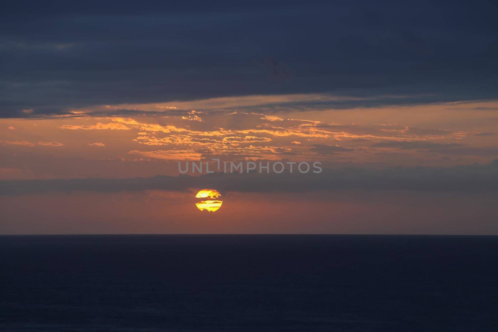 Sunrise over vast open ocean with overcast morning sky, Mossel Bay, South Africa