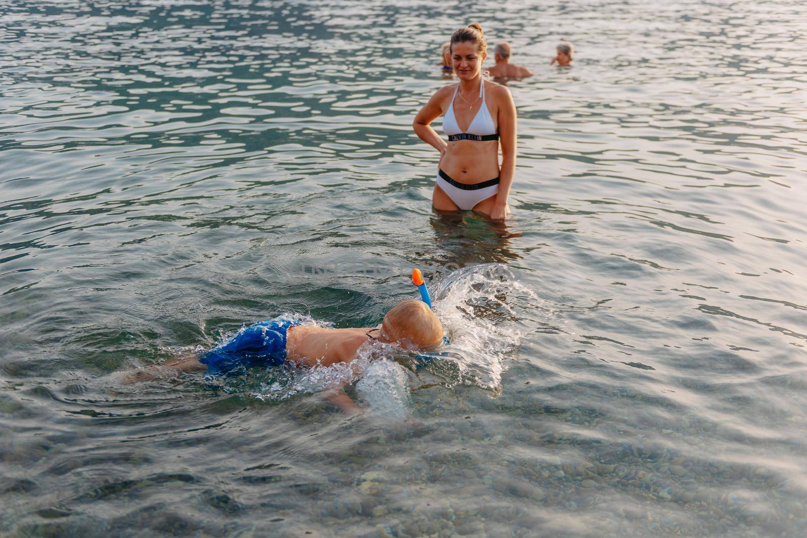 Cute happy little boy swimming and snorking in the sea. Child wearing snorkeling mask diving underwater, little boy enjoy swim underwater on tropical resort by Andrii_Ko