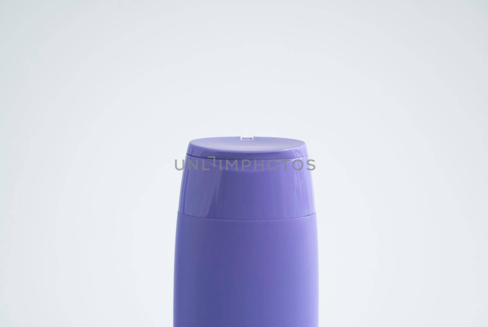 Violet plastic bottle of body care and beauty products. Studio photography of plastic bottle for shampoo, shower gel, creme isolated on white background