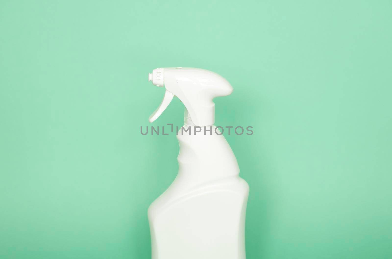 White plastic spray bottle for liquid cleaning products isolated on green background. Packaging mockup bottle with sprayer. by vovsht