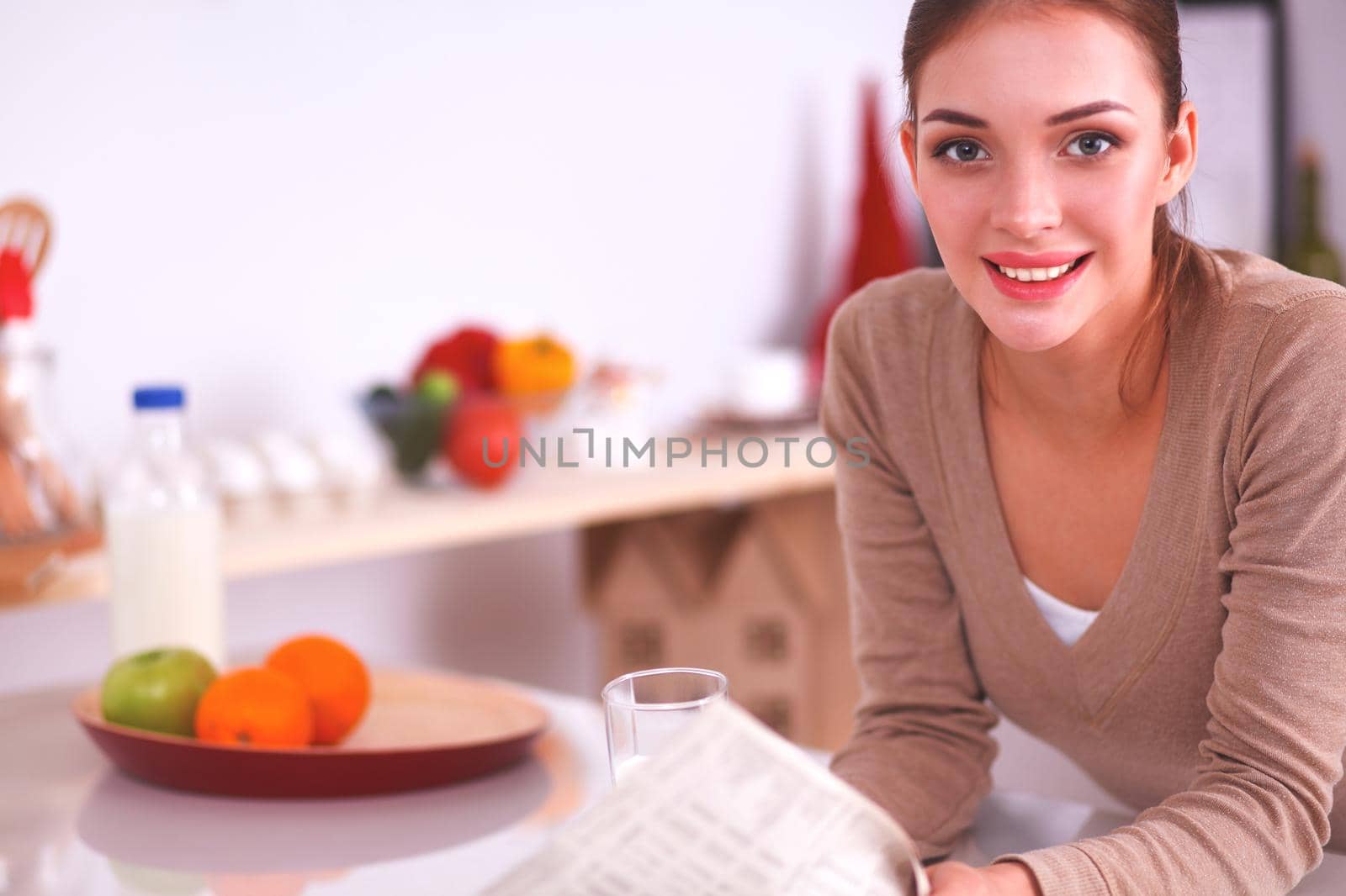 Smiling woman having breakfast in kitchen interior