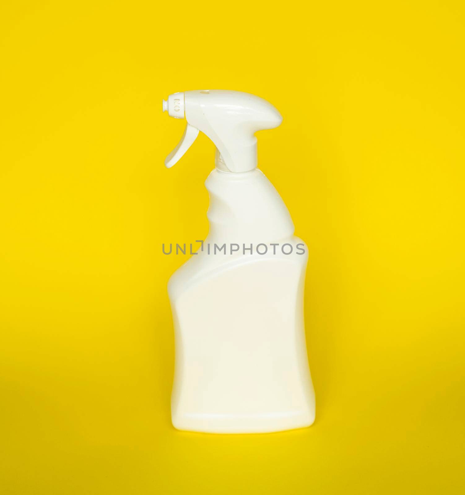 White plastic spray bottle for liquid cleaning products isolated on yellow background. Packaging mockup bottle with sprayer