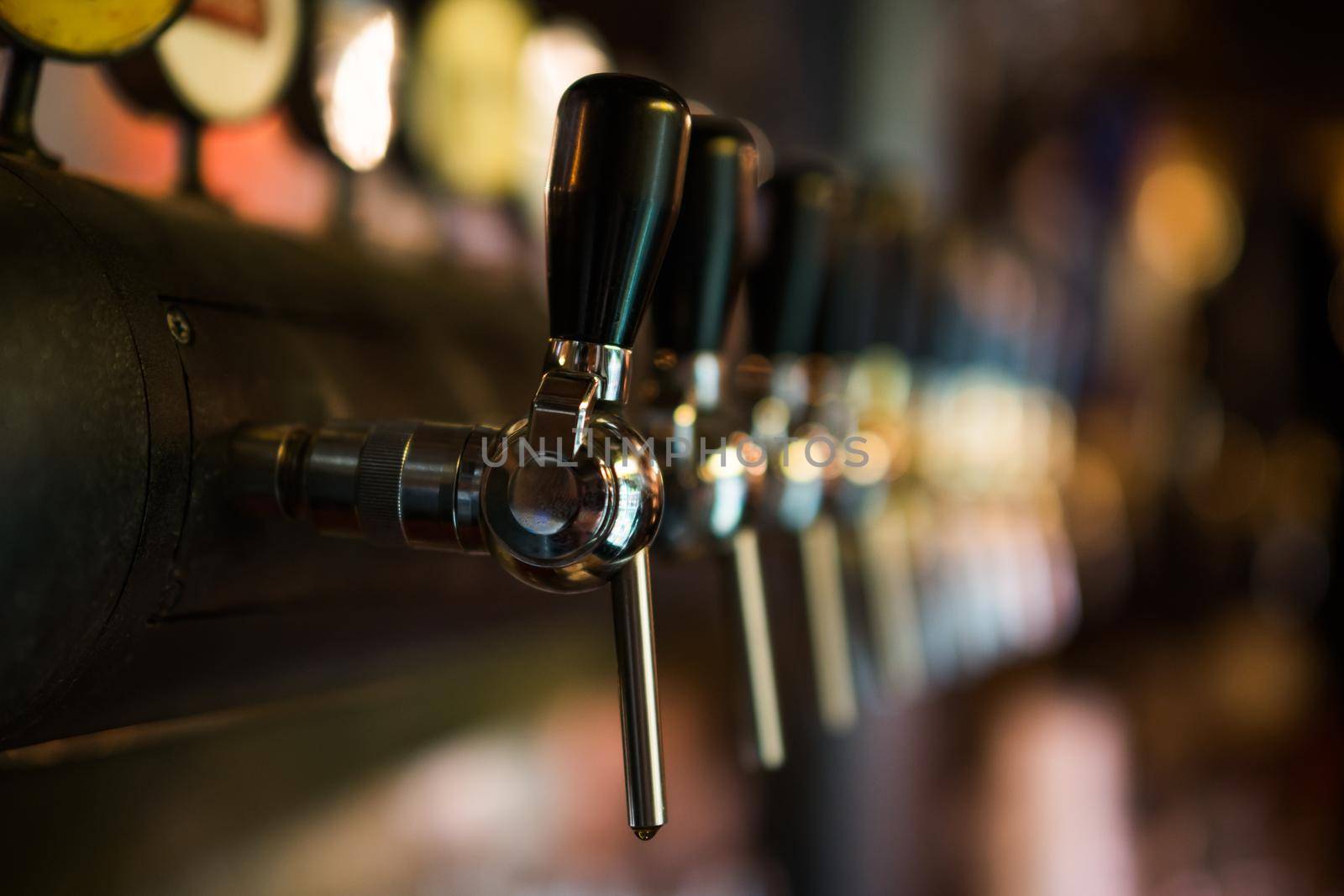 Close up image of beer taps at pub.