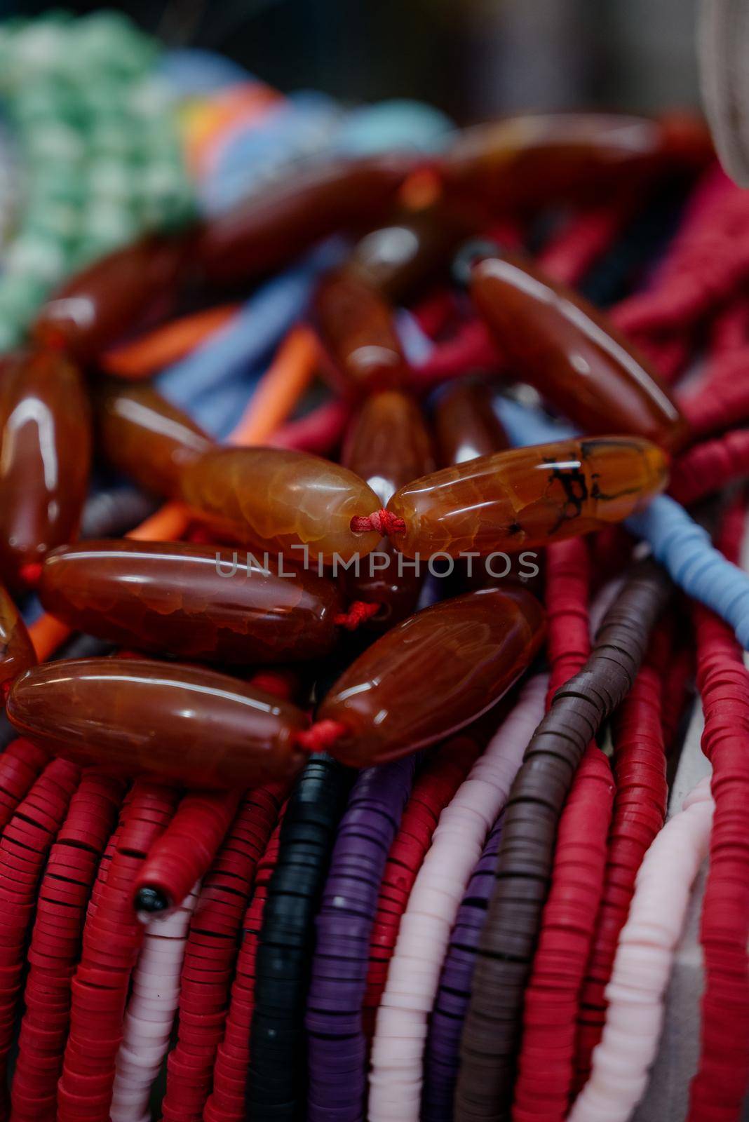 Shop window with necklaces and jewelry. Custome jewelry on display.Variety of colorful necklaces, bracelets, earrings, rings in window of costume jewelry store