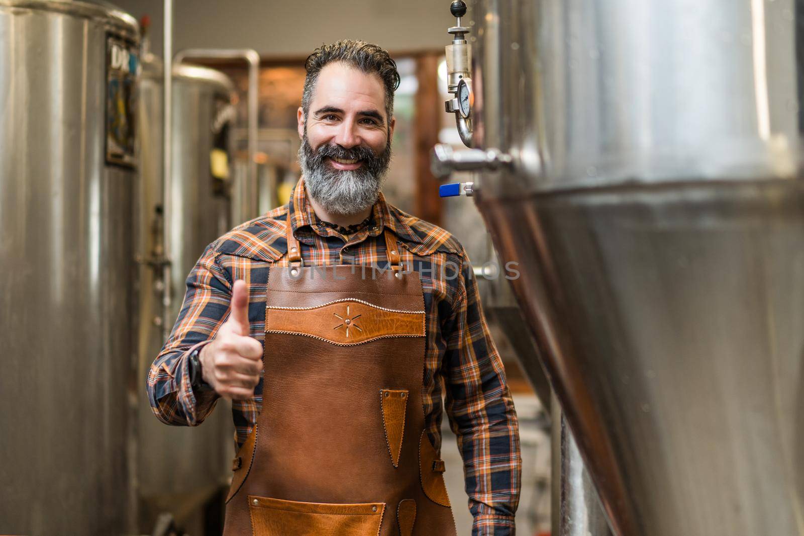 Portrait of man who is working at craft beer factory. Small family business, production of craft beer.