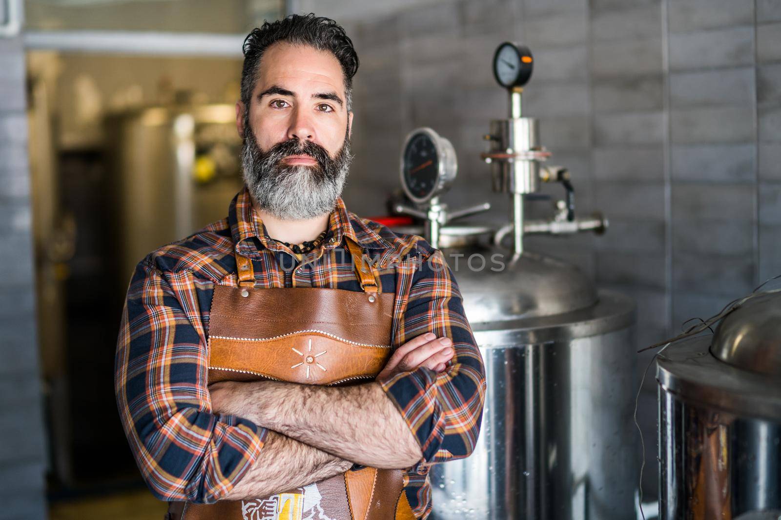 Portrait of man who is working at craft beer factory. Small family business, production of craft beer.