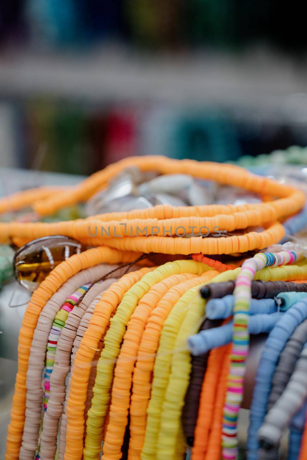 Shop window with necklaces and jewelry. Custome jewelry on display.Variety of colorful necklaces, bracelets, earrings, rings in window of costume jewelry store