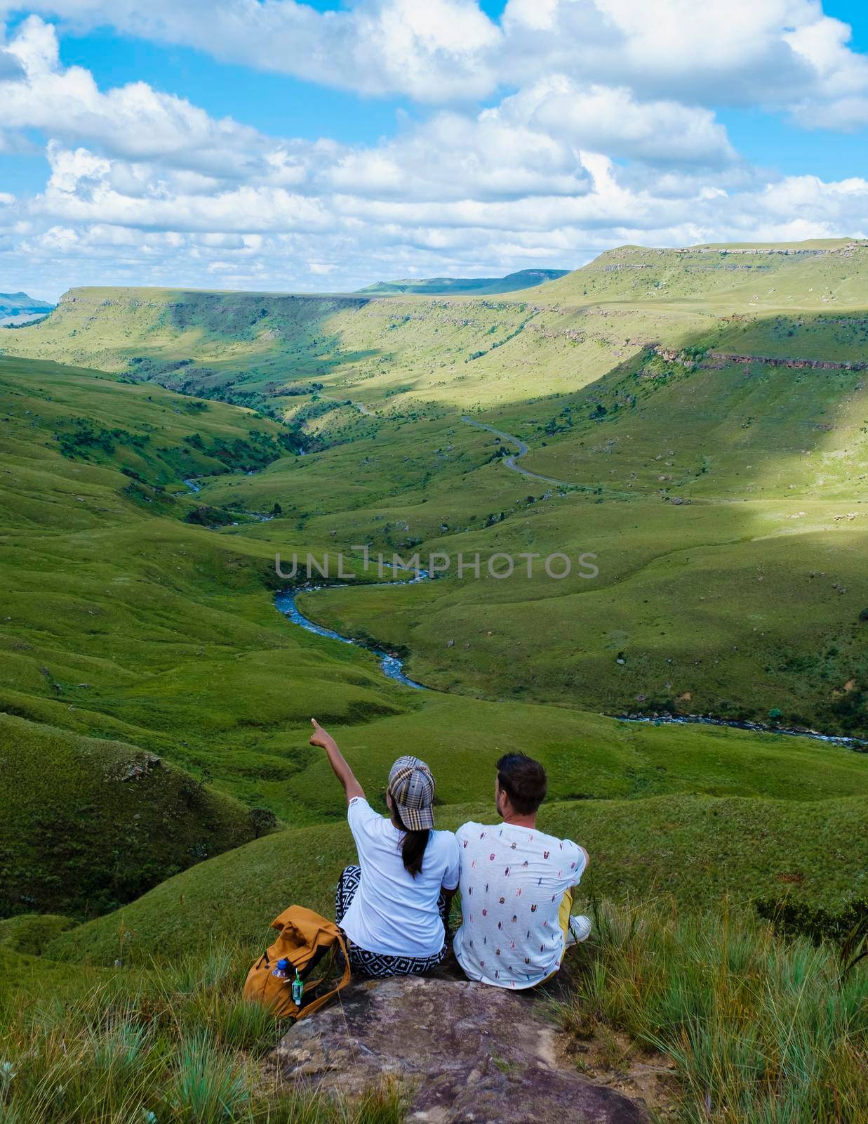 Young couple man and woman hiking in the mountains, Drakensberg Giant Castle South Africa, Drakensberg mountain,l Drakensberg Kwazulu Natal, green mountains in South Africa, a young Asian woman hiking