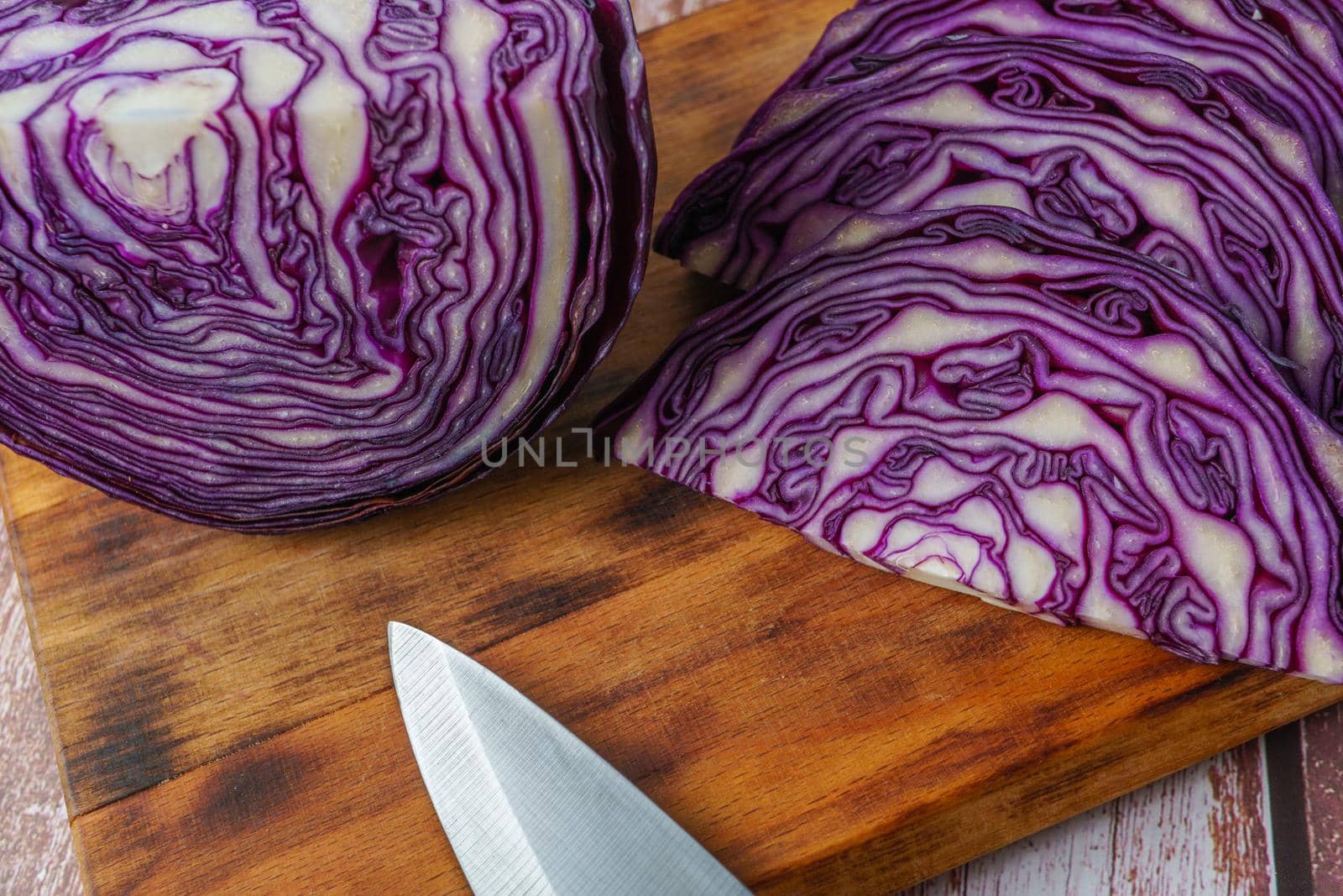 red cabbage or red cabbage with knife on wooden board by joseantona