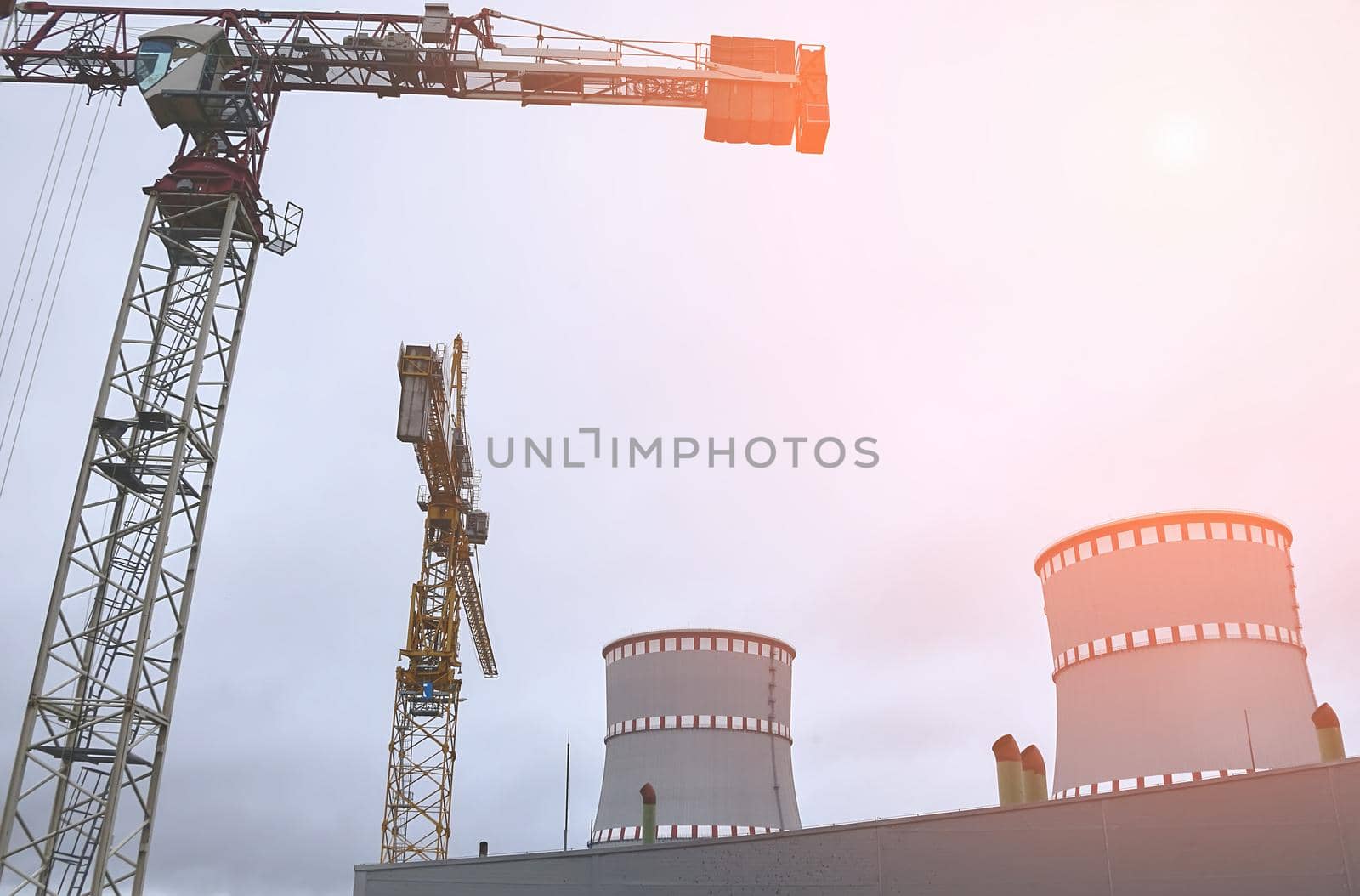 Cooling tower of an environmentally friendly nuclear power plant under construction and a lifting tower crane