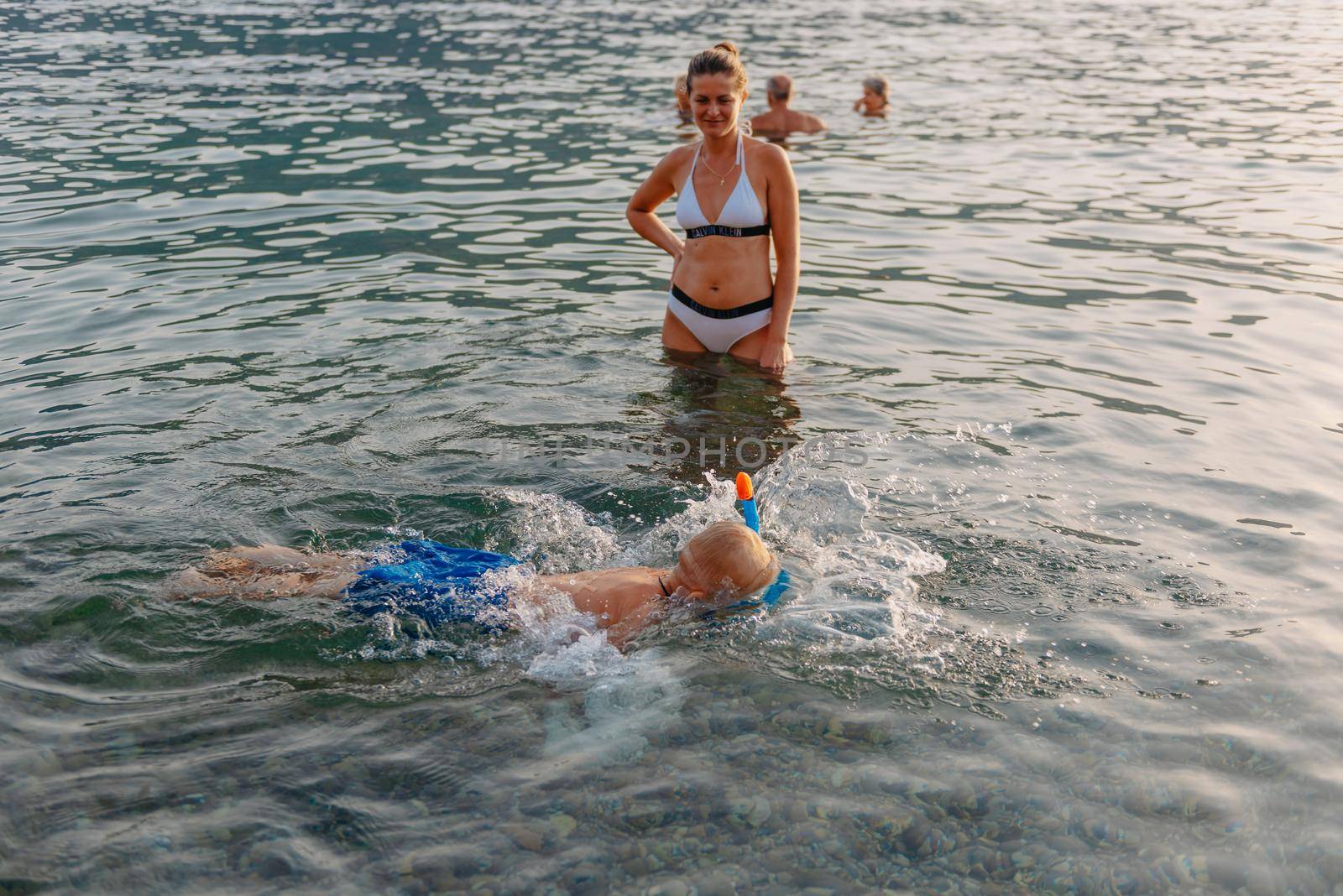 Cute happy little boy swimming and snorking in the sea. Child wearing snorkeling mask diving underwater, little boy enjoy swim underwater on tropical resort by Andrii_Ko