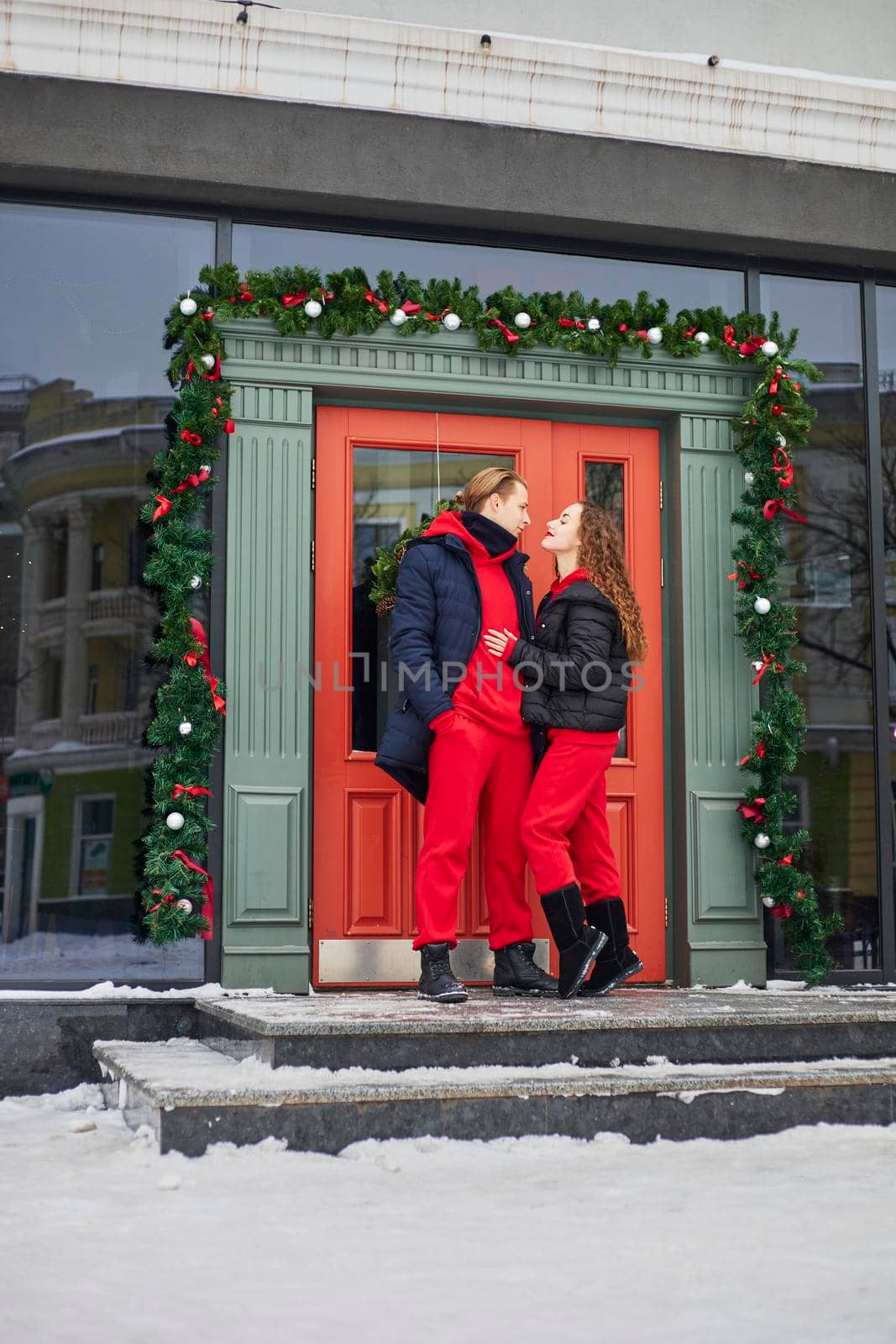 young happy family, a guy and a girl spend the day near the cafe, the guy hugs the girl