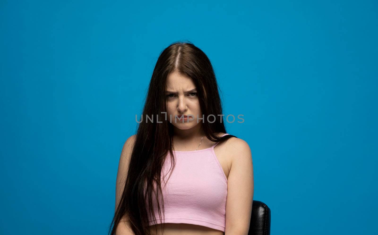 Negative human emotions and feelings. Grumpy young woman posing, frowning eyebrows, her look and grimace expressing anger, annoyance and dislike