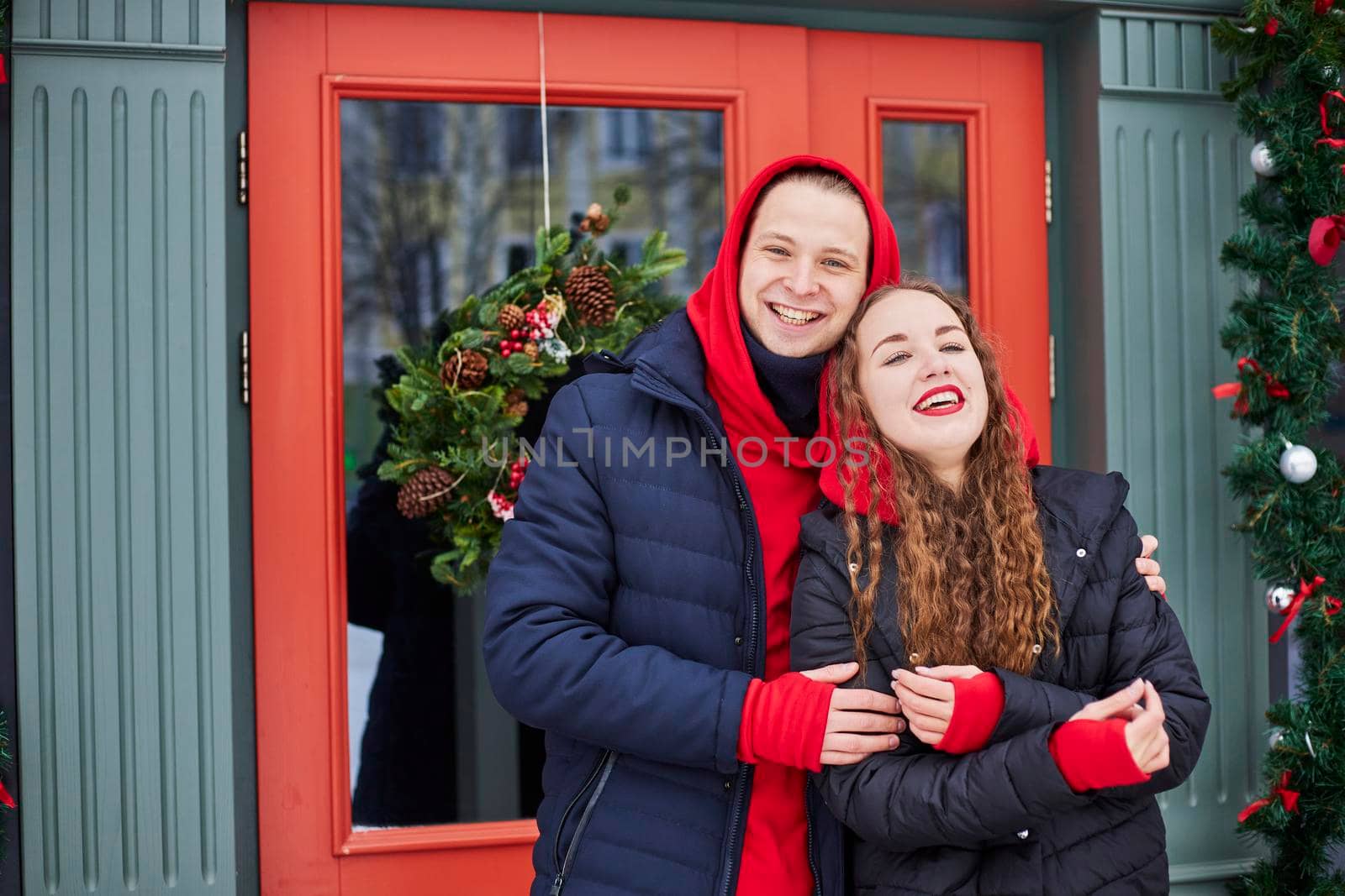 young happy family, a guy and a girl spend the day near the cafe, the guy hugs the girl