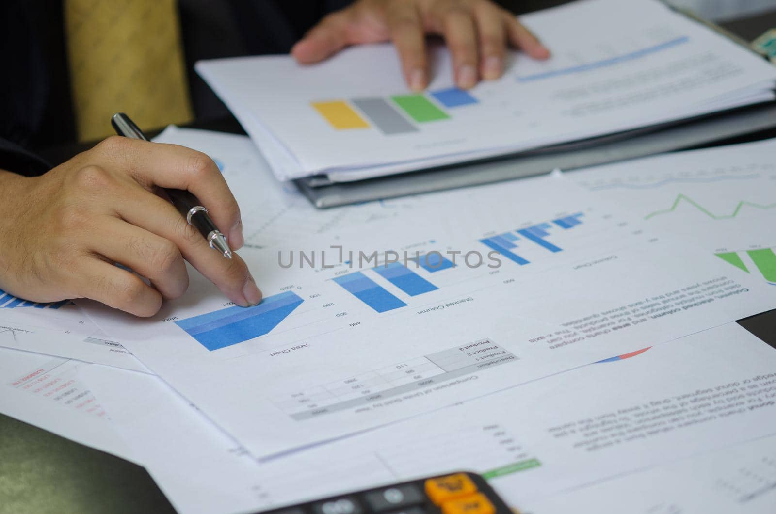 Businessman working in an office with a laptop with data documents graphs and charts marketing research statistics and financial development.