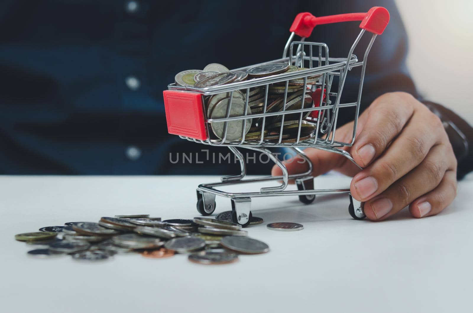 Business finance investment economy or shopping online marketing and saving tax concept.Businessman holding cart at coin.