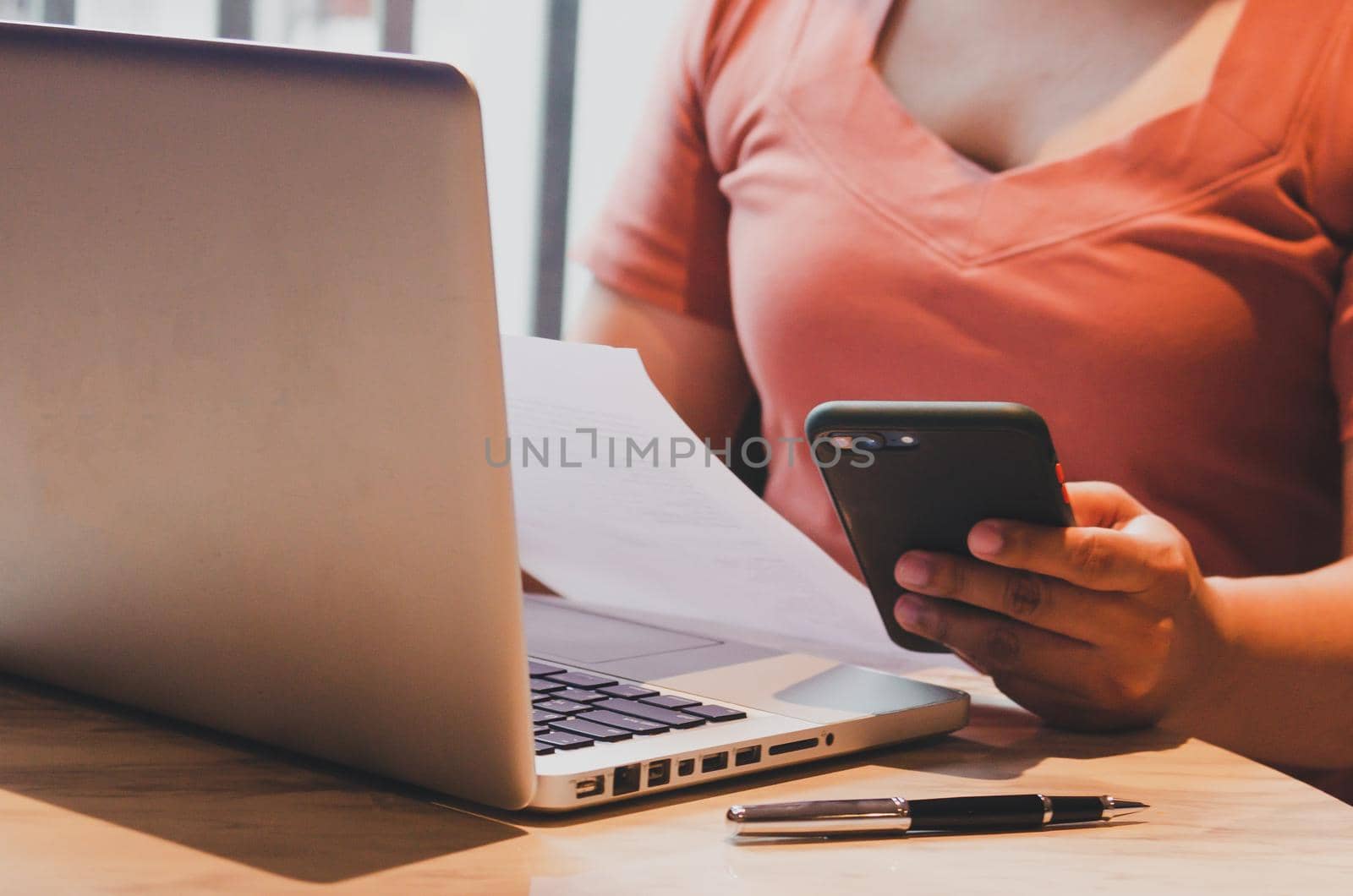 Businesswoman holding mobile smartphone and document planning marketing with computer laptop on desk. by aoo3771