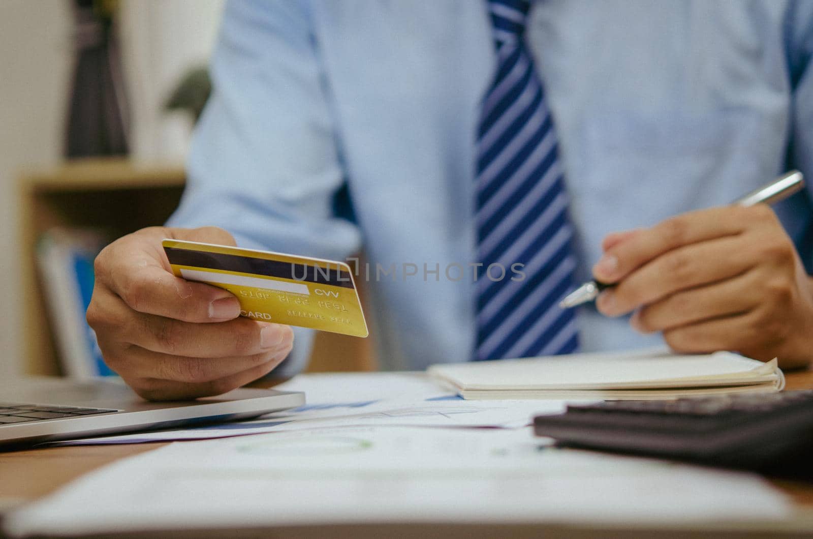employee of a company paying a charge with a credit card while conducting internet shopping. Concept of tax and accounting in business. by aoo3771