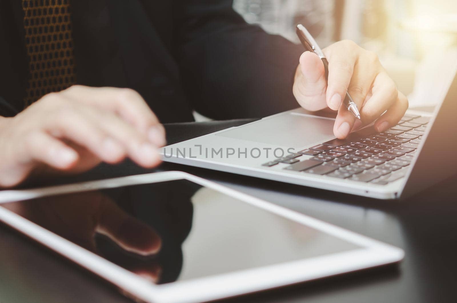 Businessman holding pen typing keyboard computer laptop and tablet on desk. Business technology digital internet work job research and communication concept.