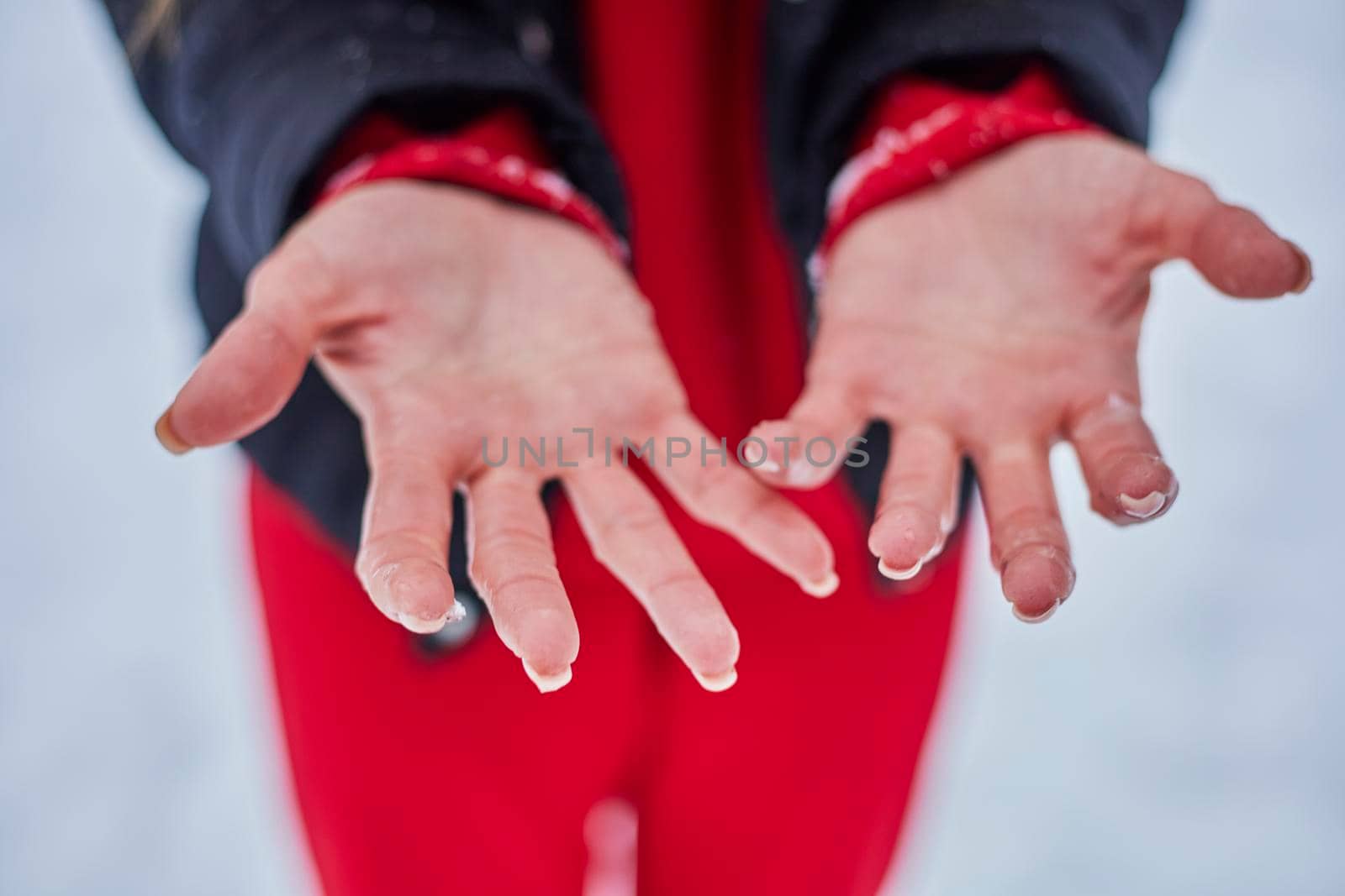 hands of a young woman, close-up, frozen from playing snowballs